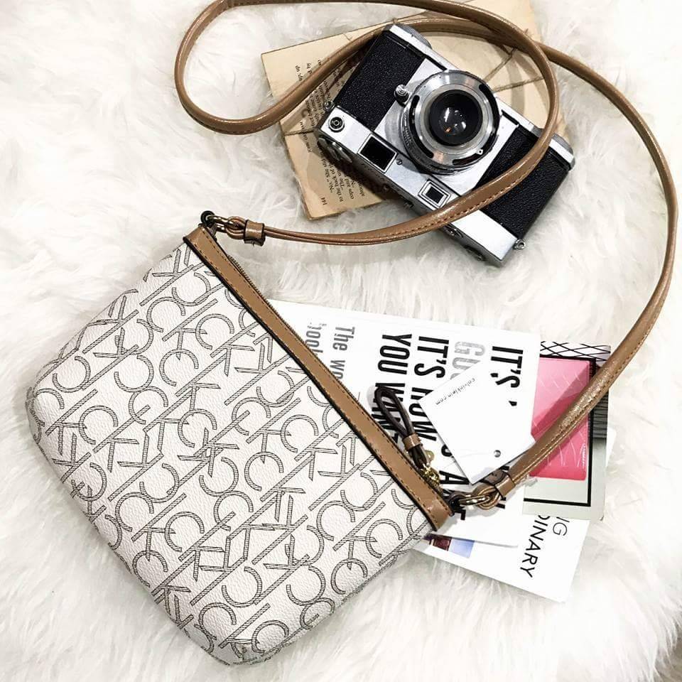 Calvin Klein Cross Body Bag กระเป๋าสะพายรุ่นใหม่ล่าสุดหนังสวย สกรีนลาย Signature แบรนด์รอบใบ ประดับโลโก้แบรนด์ สีทองด้านหน้า เปิดปิดด้วยซิป น้ำหนักเบา ภายใน โล่งกว้าง มีช่องใส่บัตร และช่องซิป ใส่ iphone+ ได้ มาพร้อมสายสะพายยาว ขนาดกำลังน่ารัก สะพายคล่องตั