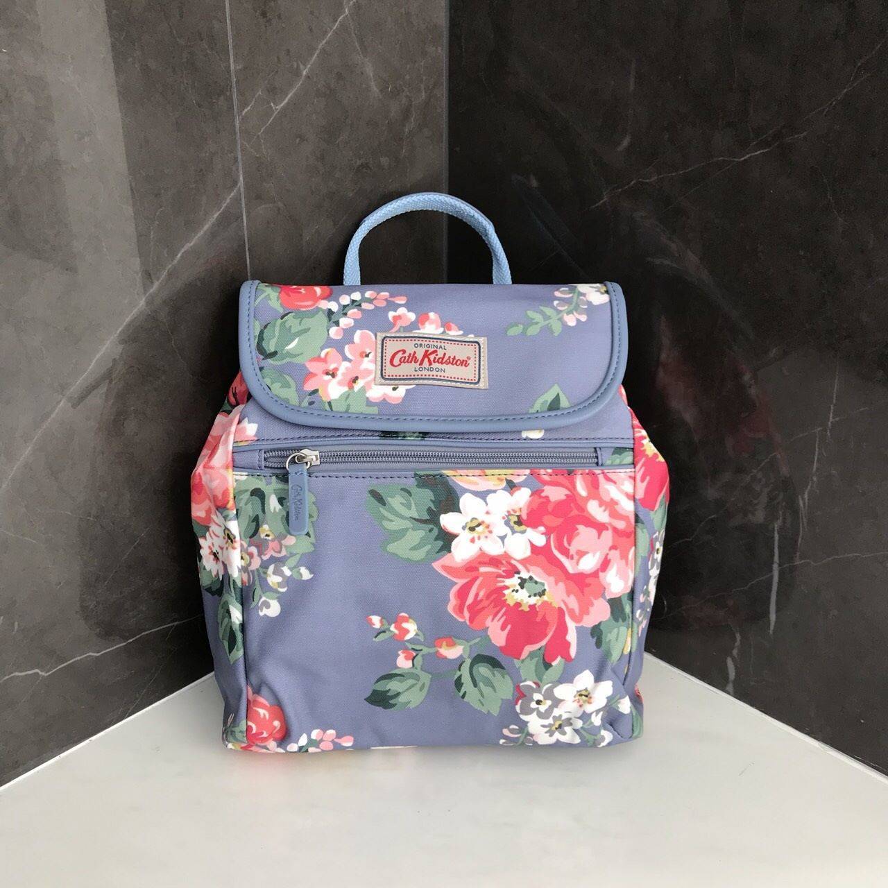 Cath Kidston Backpack Bag กระเป๋าถือหรือเป้สะพายหลัง วัสดุCanvas+Polyester อย่างดี เนื้อหนา น้ำหนักเบา ประดับโลโก้ด้านหน้า เปิดปิด ด้วยกระดุมเเม่เหล็กทั้งด้านนอก/ใน มีช่องซิปด้านหน้าใส่ กระเป๋าสตางค์ หรือมือถือได้ หัวซิปหนังปั๊มโลโก้ ภายในมี ช่องเล็ก 1 ช่
