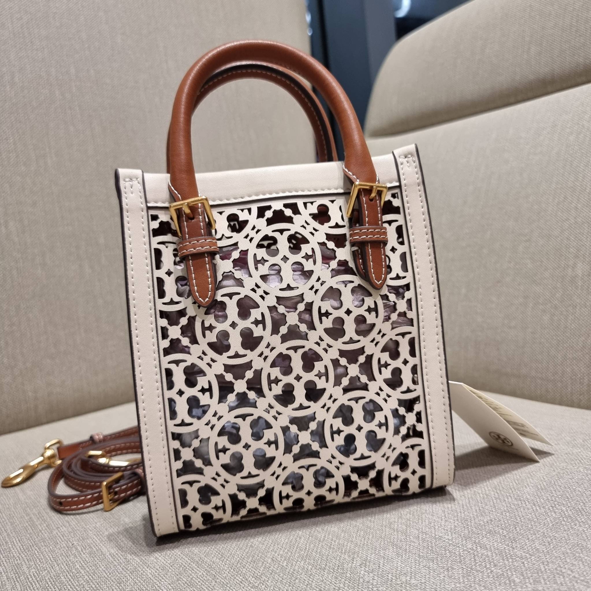 TORY BURCH T MONOGRAM LASER-CUT MINI TOTE ใจบางที่สุดกับคอลเลคชั่นนี้ กับกระเป๋าสะพายทรงโท้ท ไซส์มินิ ที่เพิ่มดีเทลความแพงด้วยการฉลุลวดลายโมโนแกรมรอบใบ ถักทอเป็นเส้นลายสานที่สวยงามมาก งานฝีมือจริงๆ วัสดุหนัง cowhide ปากกระเป๋ามีแถบแม่เหล็กกันหล่น และมีหูจ