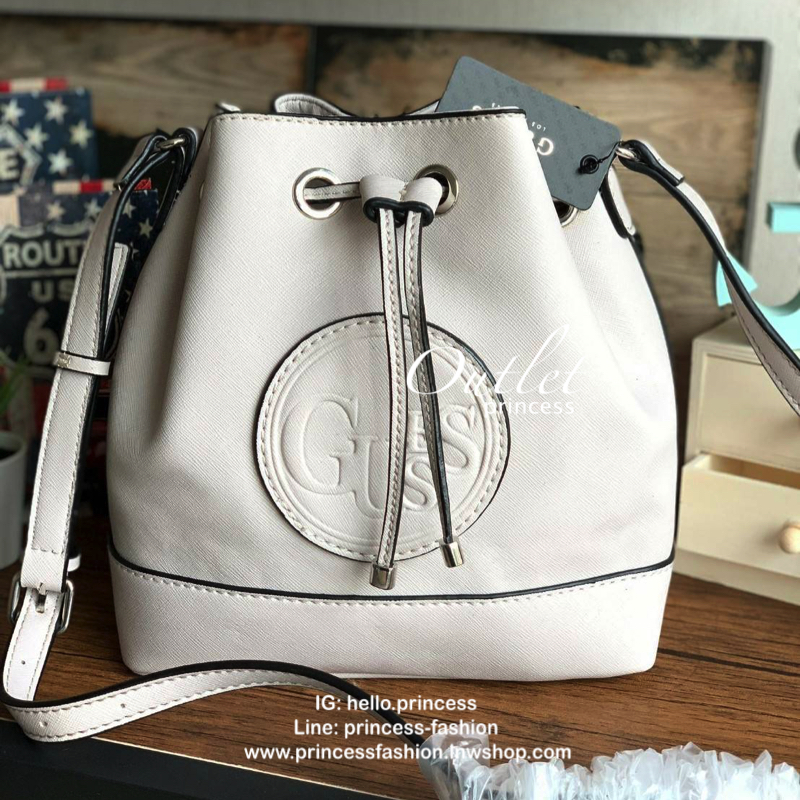 Guess Drawstring Bucket Bag กระเป๋าสะพายขนาดกลาง วัสดุลายหนังsaffiano ฐานกว้างตั้งอยู่ทรง มีซิกเนเจอร์ที่ด้านหน้าเป็นโลโก้ตัวนูน เปิดปิดแบบหูรูดและกระดุมแม่เหล็ก มีช่องใช้งานหลายข่อง สายสะพายปรับได้แบบเข็มขัด สวยแบบมีดีเทลเก๋ๆ สะพายเที่ยวระหว่างวันได้สบาย