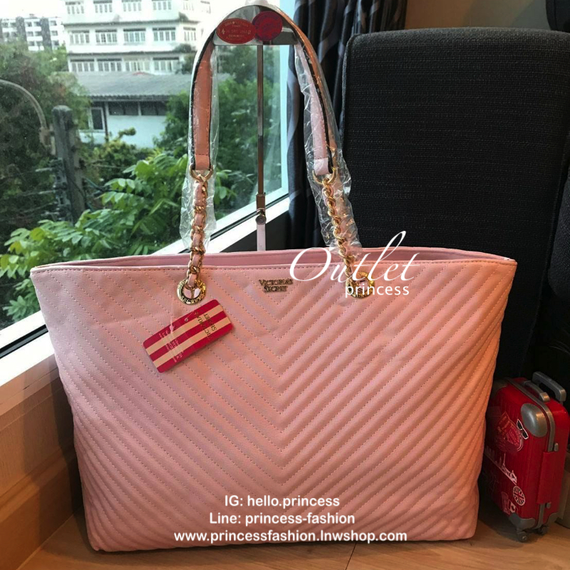 Victoria’s Secret Quileted Tote Bag กระเป๋าถือหรือสะพายลายหนังแกะสังเคราะห์อยู่ทรงสวย ดีไซน์ลายริ้วเป็นตัววี ด้านหน้าประดับด้วยโลโก้อะไหล่ทอง เปิดปิดด้วยซิปเดียว ภายในมีช่องโล่งและช่องเล็กไว้แบ่งเก็บของ ใส่หนังสือ เอกสาร A4 Notebook ipad กระเป๋าสตางค์ ของ