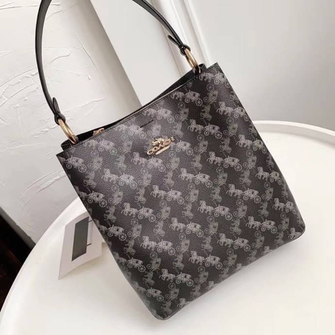 COACH TOWN BUCKET BAG WITH HORSE AND CARRIAGE PRINT ((2081-236)) 🔺กลับมาแล้ว ตามคำเรียกร้องค่ะ! กระเป๋าคล้องไหล่//สะพายข้างได้ วัสดุ pvc อย่างดี หนังนิ่มป่องพองตัวสวยงาม ลายรถม้าทั้งใบค่ะ ภายในกระเป๋าแบ่งเป็น2ช่องหลัก เปิดปิดแบบกระดุมแม่เหล็ก ภายใ
