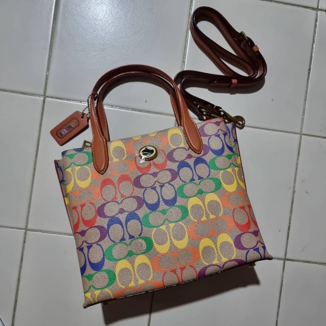 COACH CA102 WILLOW TOTE 24 IN RAINBOW SIGNATURE CANVAS ไปให้สุดกับความเลิศของลวดลายสายรุ้ง ที่แต่งแต้มลงบนกระเป๋าทรงโท้ท ไซส์กำลังสวย พกพาได้สะดวก มีตัวบิดล็อคที่ปากกระเป๋าด้านหนึ่ง และกระดุมแม่เหล็กอีกด้านหนึ่ง ภายในโล่งกว้าง เก็บของได้เป็นสัดส่วนไปเลย ม