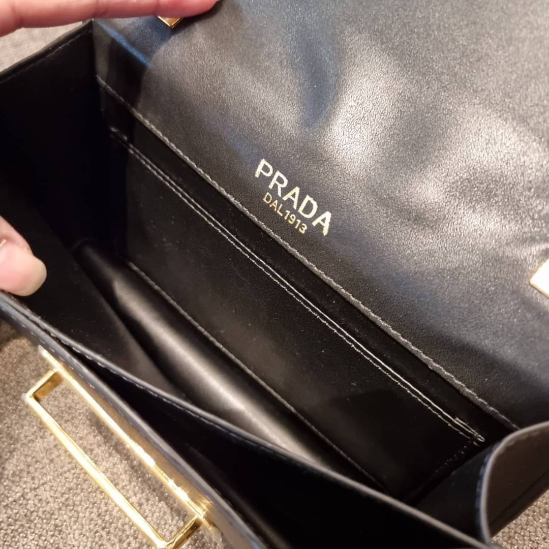PRADA FRAGRANCE SHOULDER BAG WITH GWP ไอเท็มสุดโปรดที่ควรค่าแก่การครอบครองและเก็บสะสม กระเป๋าสะพายไหล่ สวยคม สีดำคลาสสิคตัดกับอะไหล่ทองเป็นอย่างดี วัสดุหนังแท้เต็มใบ เปิดปิดด้วยแถบหนังสอดในช่อง ใช้งานสะดวก พกพาง่าย ขนาดกำลังสวย สายสะพายในตัว สะพายได้หลากห