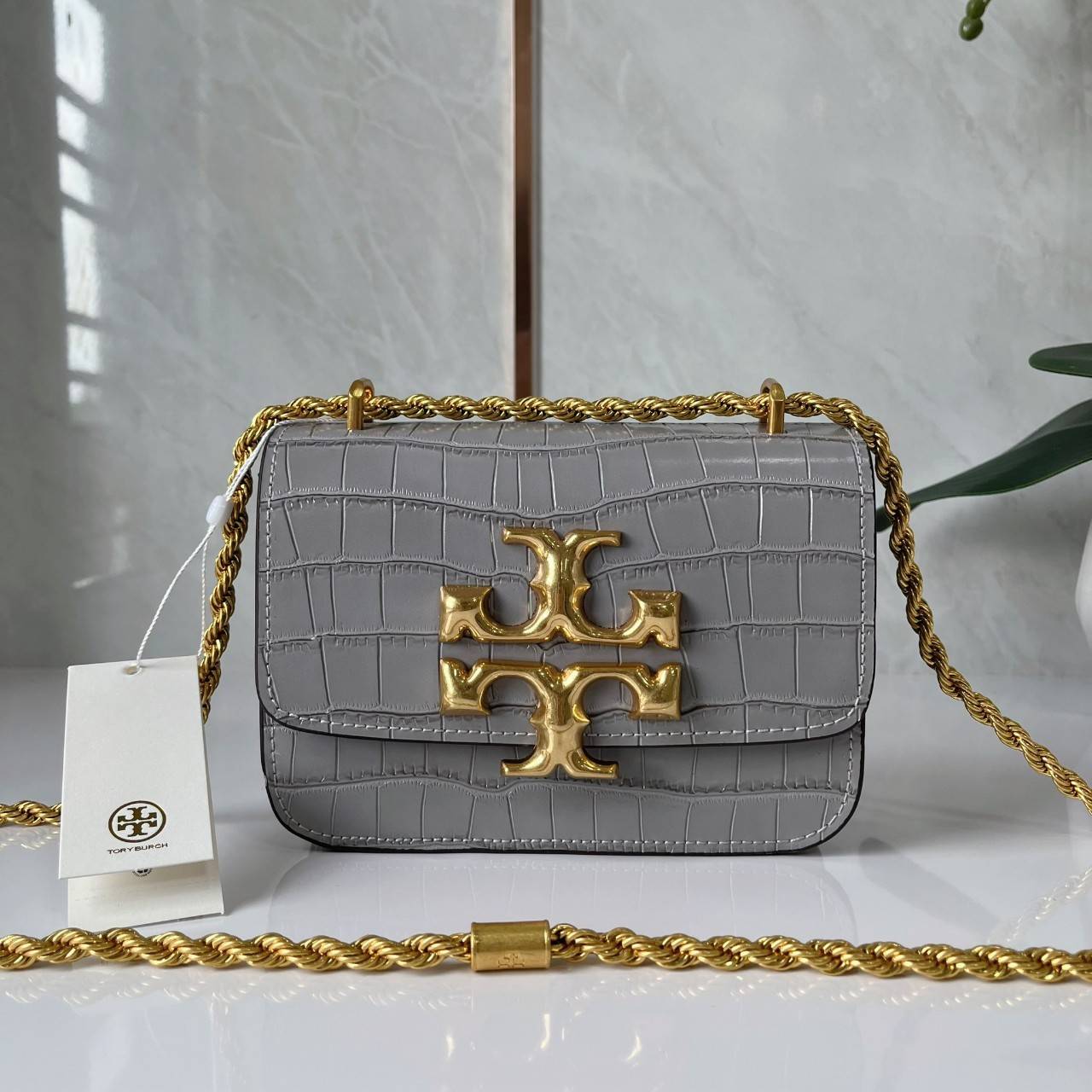 6 สี Tory Burch Croc Eleanor Small Bag / TORY BURCH ELEANOR CROC EMBOSSED LEATHER กระเป๋าสะพายหนังพิมพ์ลายจระเข้ ดีไซน์หรูหรา โด่นเด่นด้วยโลโก้แบรนด์อะไหล่ด้านหน้า และสายสะพายโลหะสีทอง