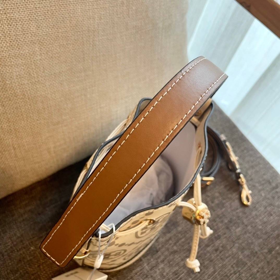 Tory Burch T Monogram Embossed Mini Bucket Bag กระเป๋าทรงถังขนาดเล็ก ประดับด้วยลวดลายอันเป็นสัญลักษณ์ของแบรนด์ ถูกประดิษขึ้นด้วยความพิถีพิถันวัสดุหนังอย่างดี ด้านในบุด้วยหนังไมโครซูแอคเนื้อนุ่มทำความสะอาดง่าย อะไหล่ทองหรูหรา มาพร้อมสายยาว ปรับสายได้ ถอดสา