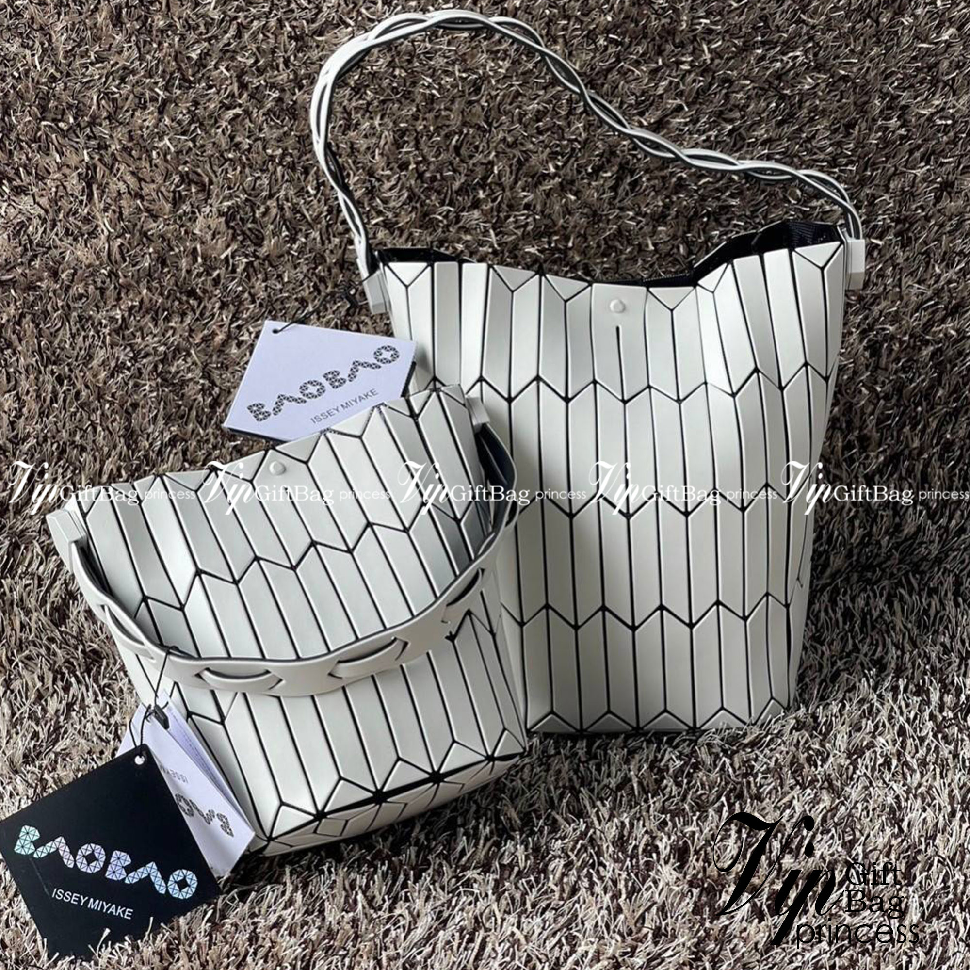 Large : Baobao Issey Miyake Large Bucket กระเป๋าบัคเก็ตขนาดใหญ่สามารถใช้ใส่ร่มพับได้หรือขวดน้ำขนาดเล็กได้ ซีรีย์ใหม่นี้มีจุดเด่นที่แผ่นรูปทรงสี่เหลี่ยมด้านขนานในแนวตั้ง เกิดเป็นรูปทรงสามมิติซึ่งแตกต่างไปจากรูปทรงที่เกิดขึ้นจากแผ่นสามเหลี่ยม หูหิ้วสามารถขย