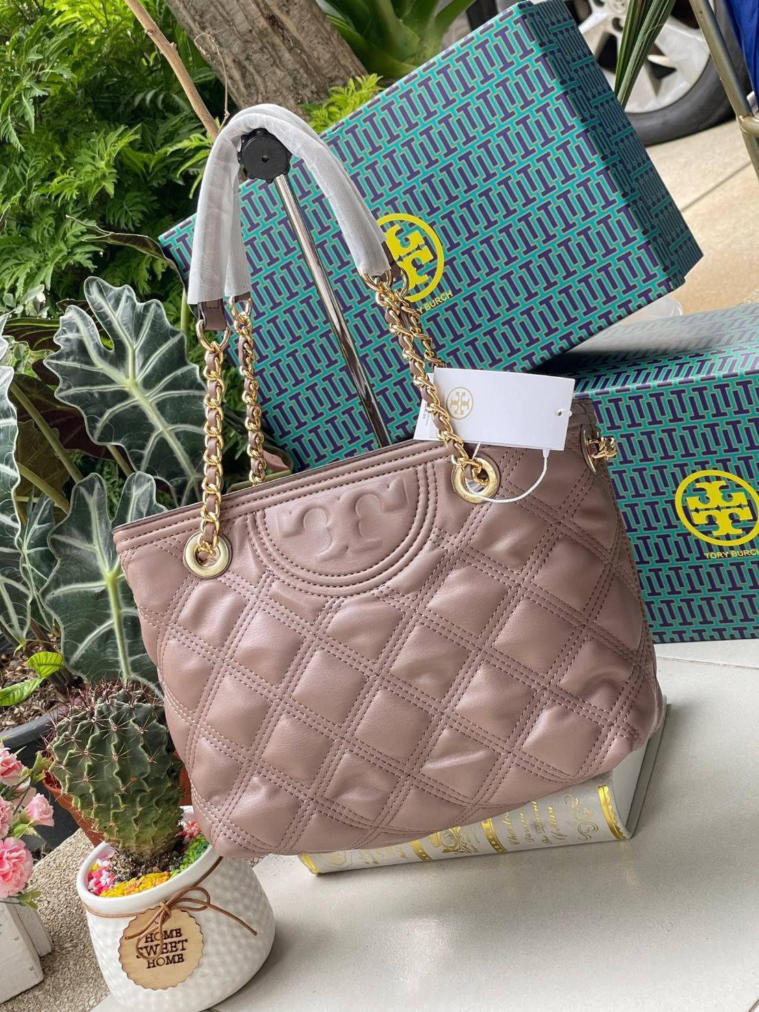 Tory Burch Fleming Soft Small Tote Bag เป็นกระเป๋าสะพายไหล่น่ารัก ๆ สักใบที่มีดีไซน์โดดเด่น สะดุดตา ใน Collection เรียกได้ว่าขายดีอันดับต้น ๆ ของแบรนด์ ใช้ได้ในลุคช์ทางการและกึ่งทางการ ดีเทลการตัดเย็บพิมพ์ลายนูนคู่กับแพทเทิร์นสี่เหลี่ยมทรงเพชร ที่ช่วยเพิ่