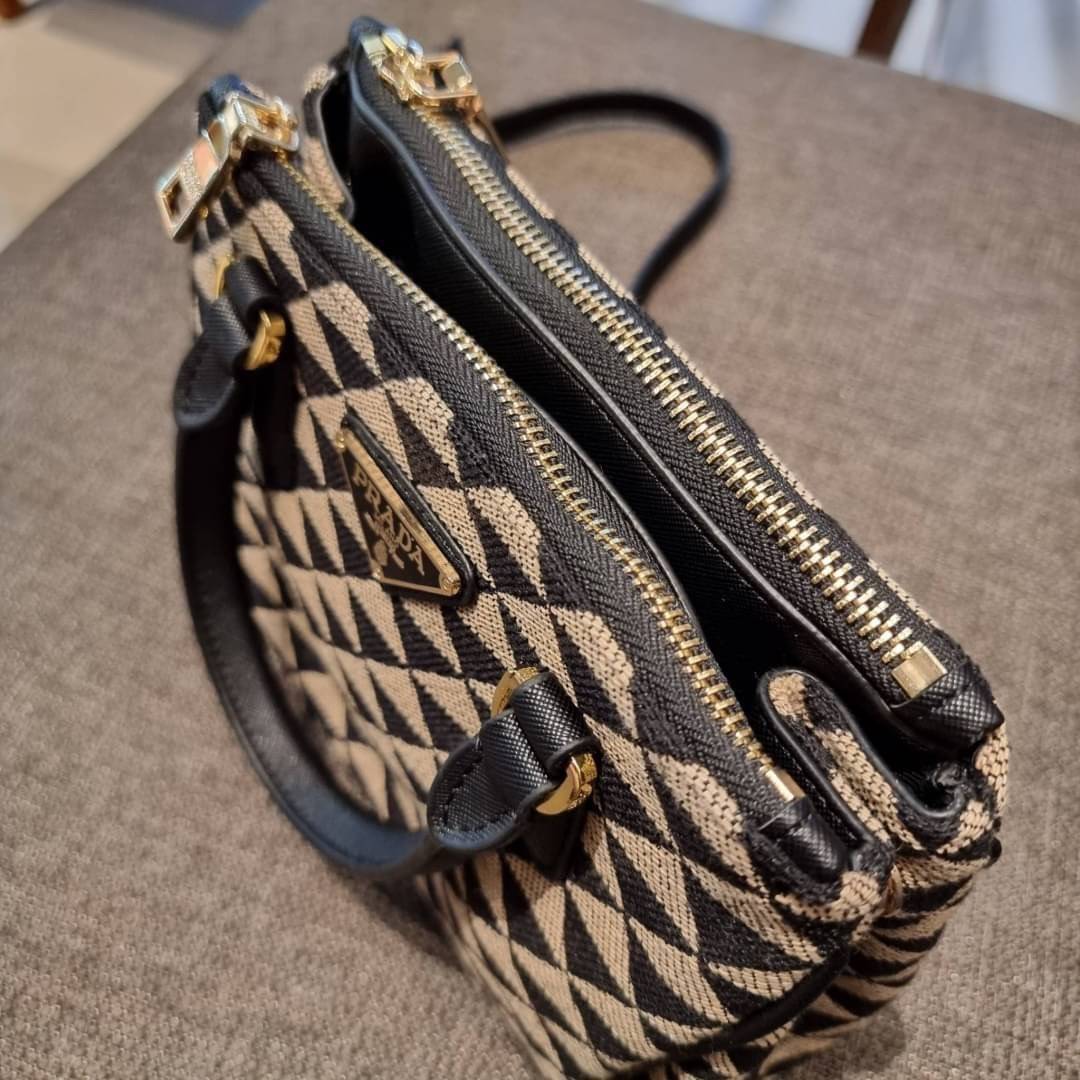 PRADA GALLERIA JACQUARD FABRIC BAG กระเป๋าถือ/สะพายดีไซน์ใหม่ ผ้า jacquard ถักทอเป็นลวดลายสวยคม โดดเด่นไม่ซ้ำใคร ด้านข้างมีกระดุม ติดเก็บทรงได้ ตัวกระเป๋าถูกแบ่งเป็นสัดส่วน เป็นช่องซิป 2 ด้าน และช่องกลางเก็บของอีกหนึ่ง มาพร้อมหูจับในตัว และสายครอสให้ เป็น