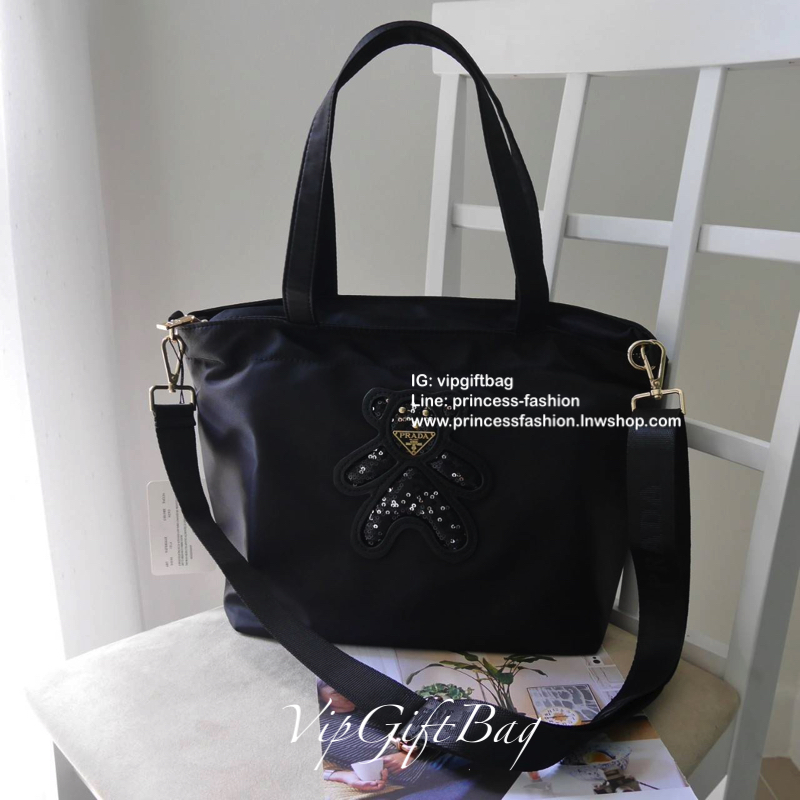 เอาใจคนชอบกระเป๋าไซส์กลาง *มาพร้อมสายยาว สำหรับกระเป๋าอเนกประสงค์ ทรง TOTE จากแบรนด์ PRADA เป็น กระเป๋าผ้าไนล่อน ตามแบบฉบับของแบรนด์เลย ใบนี้มีสายยาวให้ค่ะ เลิศมาก สะพายเป็น shoulder bag หรือ ถือได้คะ ด้านหน้าเป็นลายหมี ปั๊กกลิ้ตเตอร์ + logo brand ใช้แล้ว