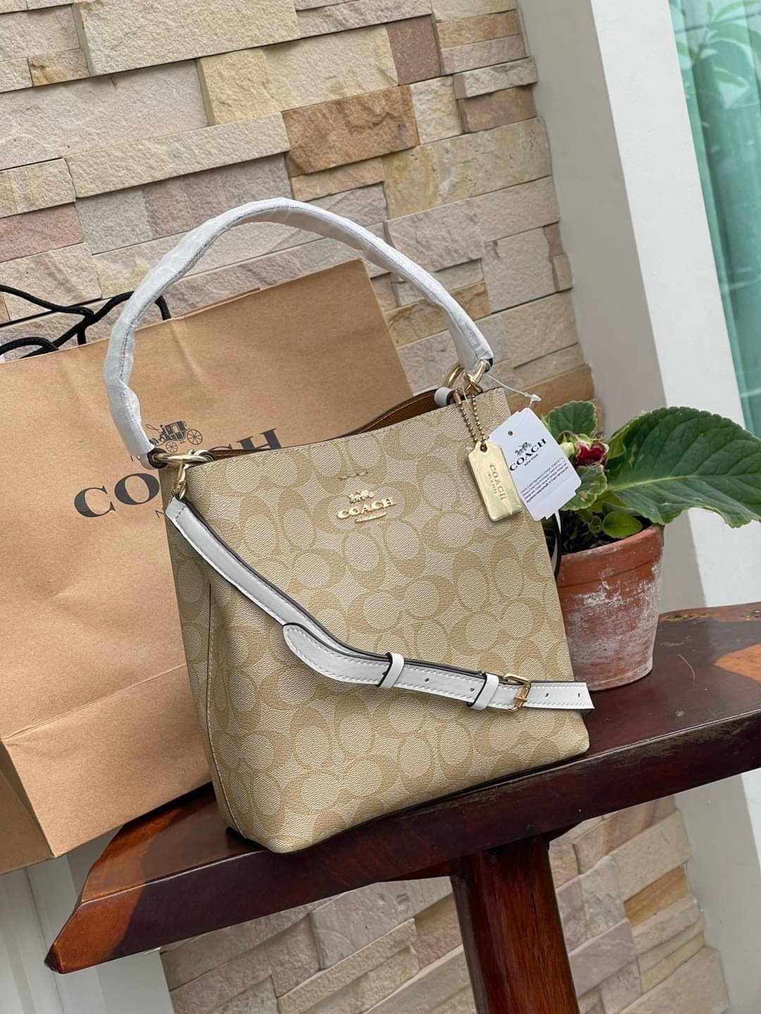 COACH SMALL TOWN BUCKET BAG IN SIGNATURE สำหรับสาวแฟชั่นที่ชอบรายละเอียดชิคๆ ดีไซน์สุดเก๋ แนะนำเลยสำหรับกระเป๋าทรงบักเก็ตใบนี้ เชื่อว่าสาว ๆ หลายคนชื่นชอบ เป็นไอเทมที่สามารถแมทช์ได้กับเสื้อหลากหลายสไตล์ บรรจุของได้เยอะโดยที่กระเป๋าไม่เสียทรง แบ่งช่องใช้งา