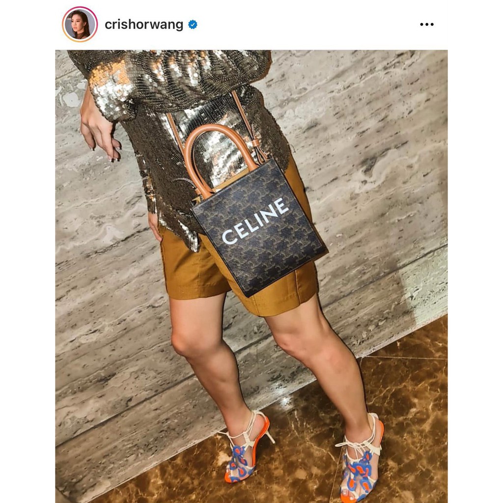 CELINE MINI VERTICAL CABAS IN TRIOMPHE CANVAS มีโลโก้ CELINE สกรีนอยู่ตรงกลาง ถือเป็นกระเป๋า Tote ที่ทำจากแคนวาสที่น่าสนใจมาก ๆ อีกรุ่นหนึ่ง และเป็นรุ่นที่ได้รับคำชื่นชมจากแฟชั่นกูรูทั้งหลายอีกด้วย หากใครที่อยากเป็นเจ้าของกระเป๋า Tote จาก CELINE สักใบ รุ่