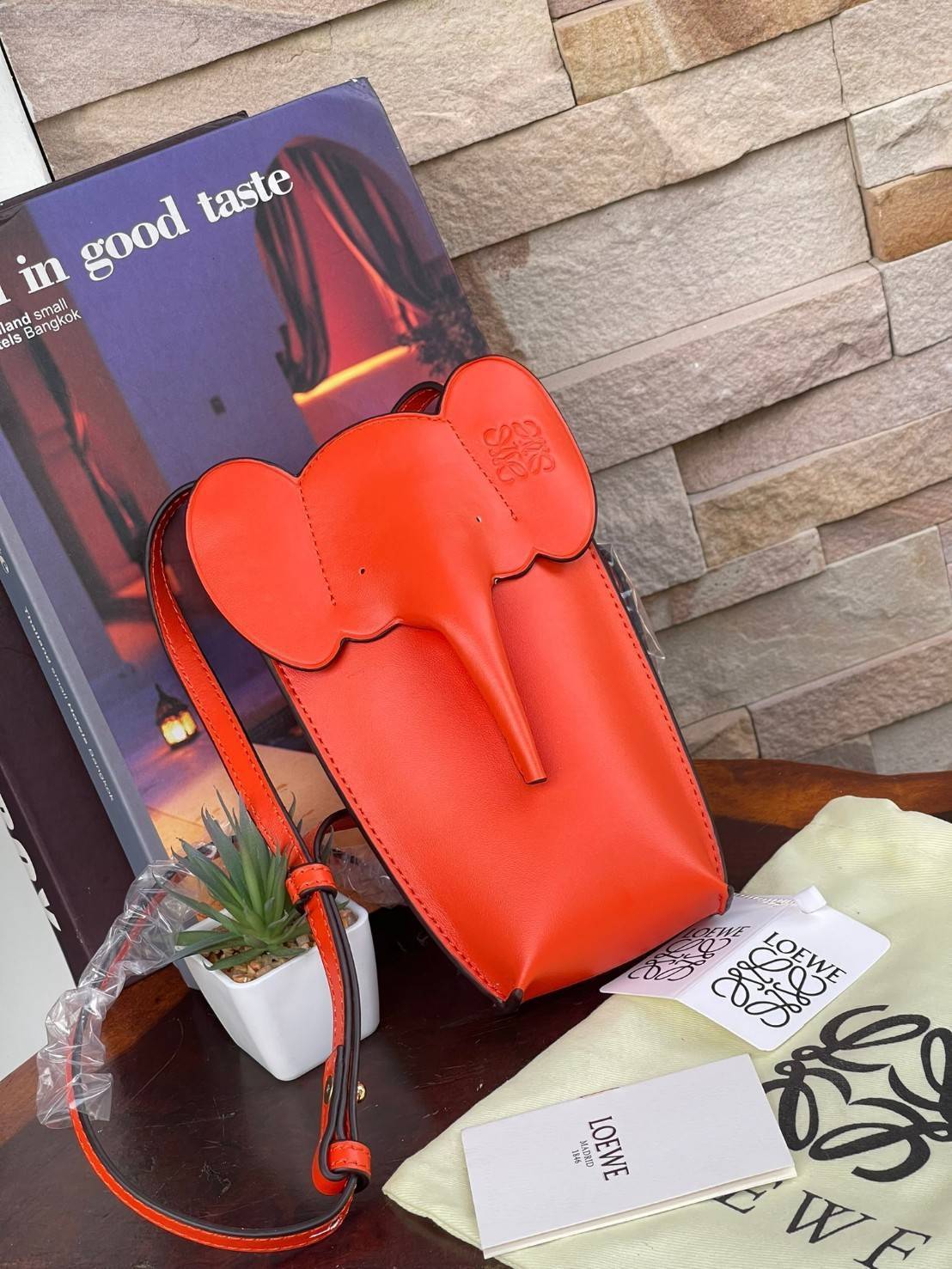 Loewe Leather Elephant Phone Holder แบรนด์หรูจากประเทศสเปนอย่าง โลเอเว่ (LOEWE) หลายๆคนคงนึกถึงกระเป๋ารูปทรงช้างขนาดเล็ก ที่เป็นเหมือนหนึ่งในซิกเนเจอร์ของแบรนด์ มีทั้งแบบสะพายข้าง แบบถือ รวมไปถึงในแบบเครื่องหนังชิ้นเล็กอย่างกระเป๋าใส่มือถือรุ่นนี้ ผลิตจาก