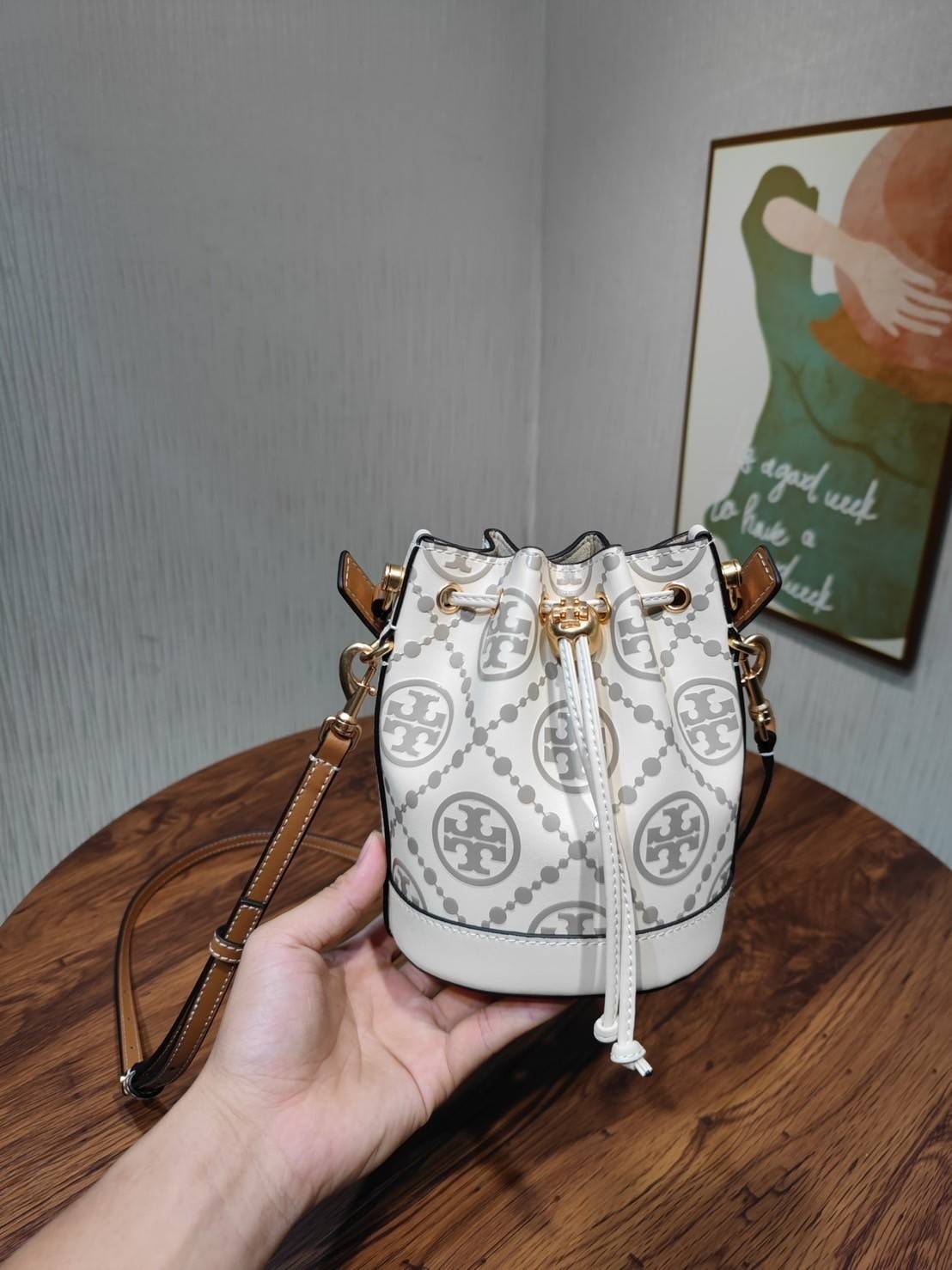 Tory Burch T Monogram Embossed Mini Bucket Bag กระเป๋าทรงถังขนาดเล็ก ประดับด้วยลวดลายอันเป็นสัญลักษณ์ของแบรนด์ ถูกประดิษขึ้นด้วยความพิถีพิถันวัสดุหนังอย่างดี ด้านในบุด้วยหนังไมโครซูแอคเนื้อนุ่มทำความสะอาดง่าย อะไหล่ทองหรูหรา มาพร้อมสายยาว ปรับสายได้ ถอดสา
