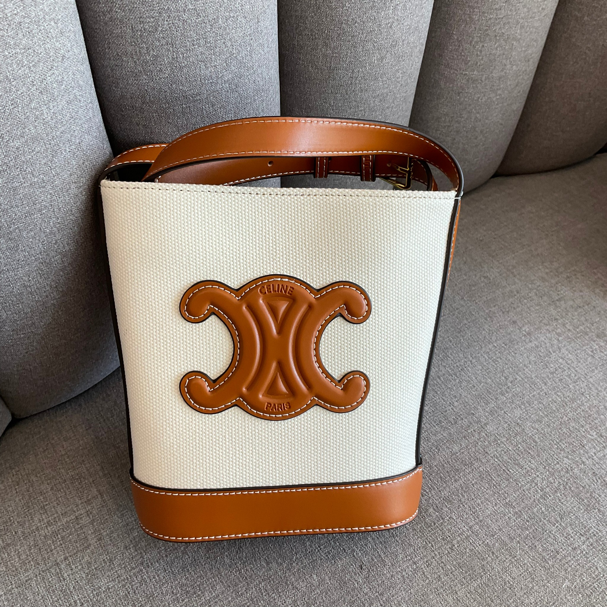 CELINE SMALL BUCKET CUIR TRIOMPHE IN TEXTILE / CELINE CROSSBODY VIP วัสดุ TRIOMPHE CANVAS สีขาวตัดกับโลโก้หนังสวยอยู่ทรงวางตั้งได้สบาย