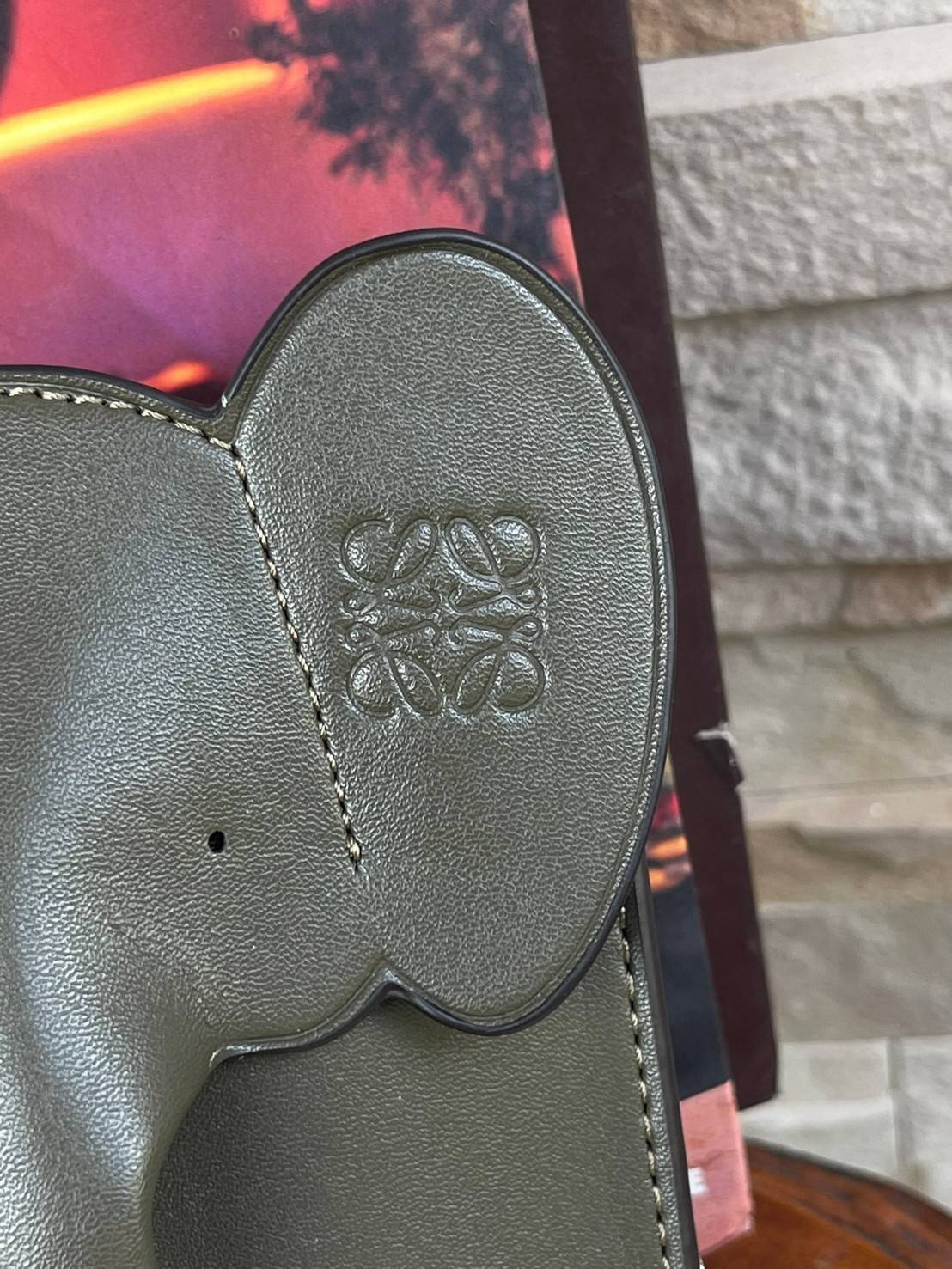 Loewe Leather Elephant Phone Holder แบรนด์หรูจากประเทศสเปนอย่าง โลเอเว่ (LOEWE) หลายๆคนคงนึกถึงกระเป๋ารูปทรงช้างขนาดเล็ก ที่เป็นเหมือนหนึ่งในซิกเนเจอร์ของแบรนด์ มีทั้งแบบสะพายข้าง แบบถือ รวมไปถึงในแบบเครื่องหนังชิ้นเล็กอย่างกระเป๋าใส่มือถือรุ่นนี้ ผลิตจาก