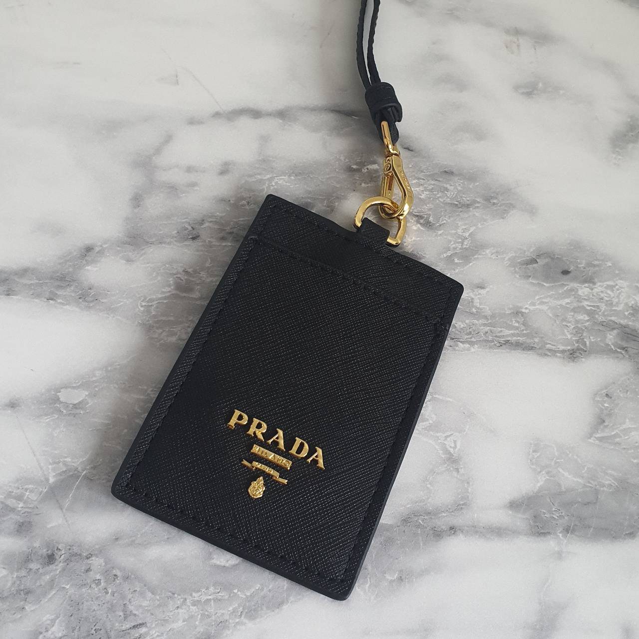 สิ้นสุดการรอคอย!! พร้อมส่งที่ไทยแล้วค่ะ สายคล้องบัตรสุดคลาสสิค จากงานพรีเมี่ยมกิ้ฟท์แบรนด์ดังอย่าง PRADA วัสดุหนังพรีเมี่ยม SAFFIANO อะไหล่ทอง ปั้มแบรนด์ ด้านหน้ามีช่องใส่บัตร1ใบ ประกับโลโก้PRADA และด้านหลังใส่บัตรได้อีกหนึ่งใบ(แบบใส) สำหรับโชว์บัตร ไอเท็