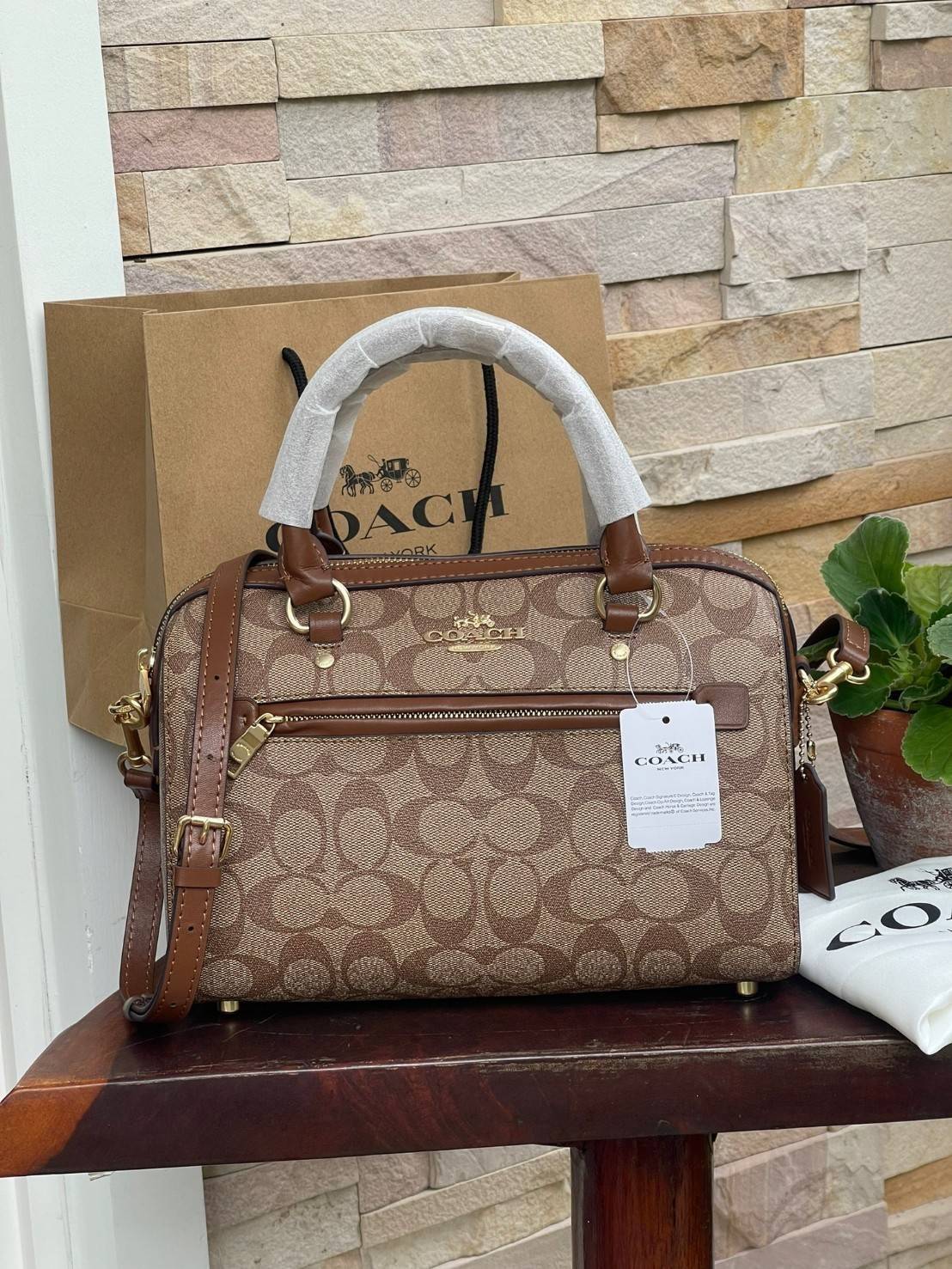 COACH Signature Canvas Rowan Satchel Crossbody จุดเด่นของกระเป๋าทรงsatchel bag คือรูปทรงของกระเป๋าดูแข็งแรง มั่นคง ไม่เสียทรงง่าย มาพร้อมหูหิ้วที่ด้านบนของกระเป๋า ลายแคนวาสที่เป็นซิกเนเจอร์แบบเอกลักษณ์ ช่องใช้งานทุ้งภายในและภายนอก นอกจากนี้ กระเป๋าประเภทน