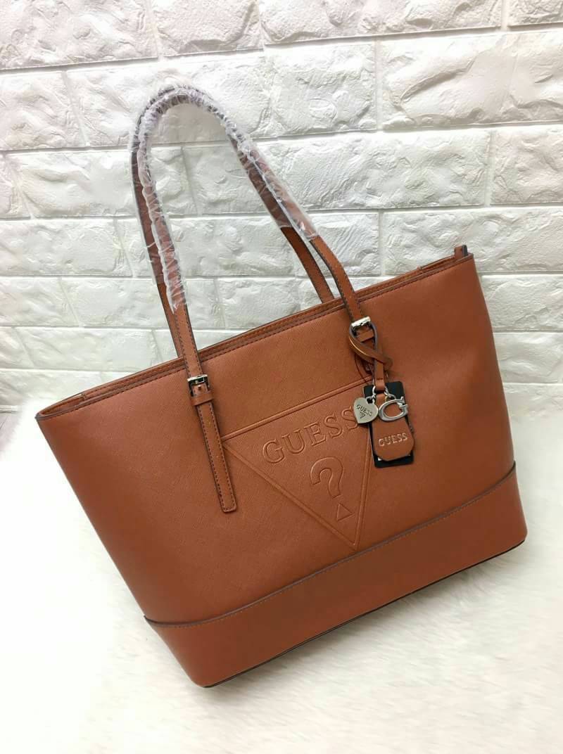 GUESS SAFFIANO SHOPPER BAG กระเป๋าสะพายทรง Tote จากแบร์น GUESS วัสดุหนัง Saffiano สวยอยู่ทรง สไตล์ PRADA ขนาดใหญ่ แต่น้ำหนักเบา ด้านหน้าปั๊มโลโก้แบรนด์ พร้อม TAG โลโก้อะไหล่ตัว G และรูปหัวใจที่หูกระเป๋า ถอดเเยกใช้ได้ เปิดปิดด้วยซิปสะดวกใช้ ภายในมีโลโก้ ช่