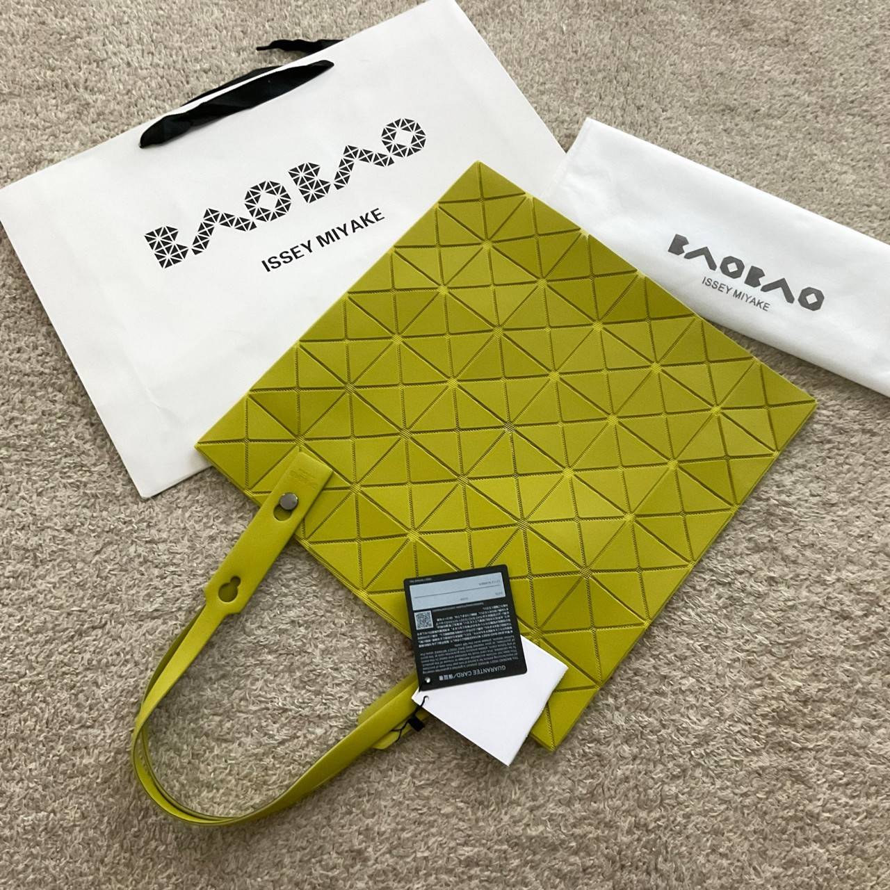 BAO BAO ISSEY MIYAKE LUCENT ONE-TONE กระเป๋าสะพายไหล่ ทรงโท้ท ใบใหญ่สวยมาก ปรับได้หลายทรงตามเอกลักษณ์เฉพาะของแบรนด์นี้ วัสดุ 100% POLYESTER PARTLY: SYMYHETIC LEATHER ด้านในใส่ของได้เยอะมาก ใส่ไอแพด สมุดโน้ตได้สบายเลย วัยทำงานหรือวัยนักศึกษา อย่างน้อยต้องม