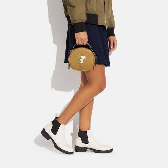 COACH X PEANUTS CANTEEN CROSSBODY WITH SNOOPY PRESENT MOTIF (CE845,CF290) กระเป๋าสะพายข้างทรงกลมไซส์มินิ มีหูจับ วัสหนังแท้ ด้านหน้าโดดเด่นด้วยรูปการ์ตูนSnoopy