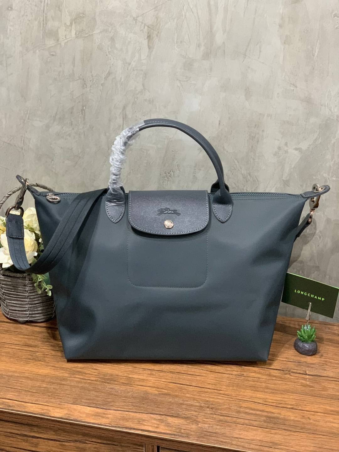 Longchamp Le Pliage Neo Size M มาพบกับกระเป๋ารุ่นยอดนิยม ที่สาวๆ ต้องมีไว้เก็บไว้สักใบ กระเป๋าโท้ทใบนี้ มาพร้อมกับสีที่มีสไตล์เรียบง่าย มีสายสะพายยาวช่วยให้คุณสามารถสะพายไหล่ได้อย่างสบาย ในขณะที่ที่ปิดแบบซิปช่วยให้คุณมั่นใจได้ว่าของด้านในมีความปลอดภัย Le 