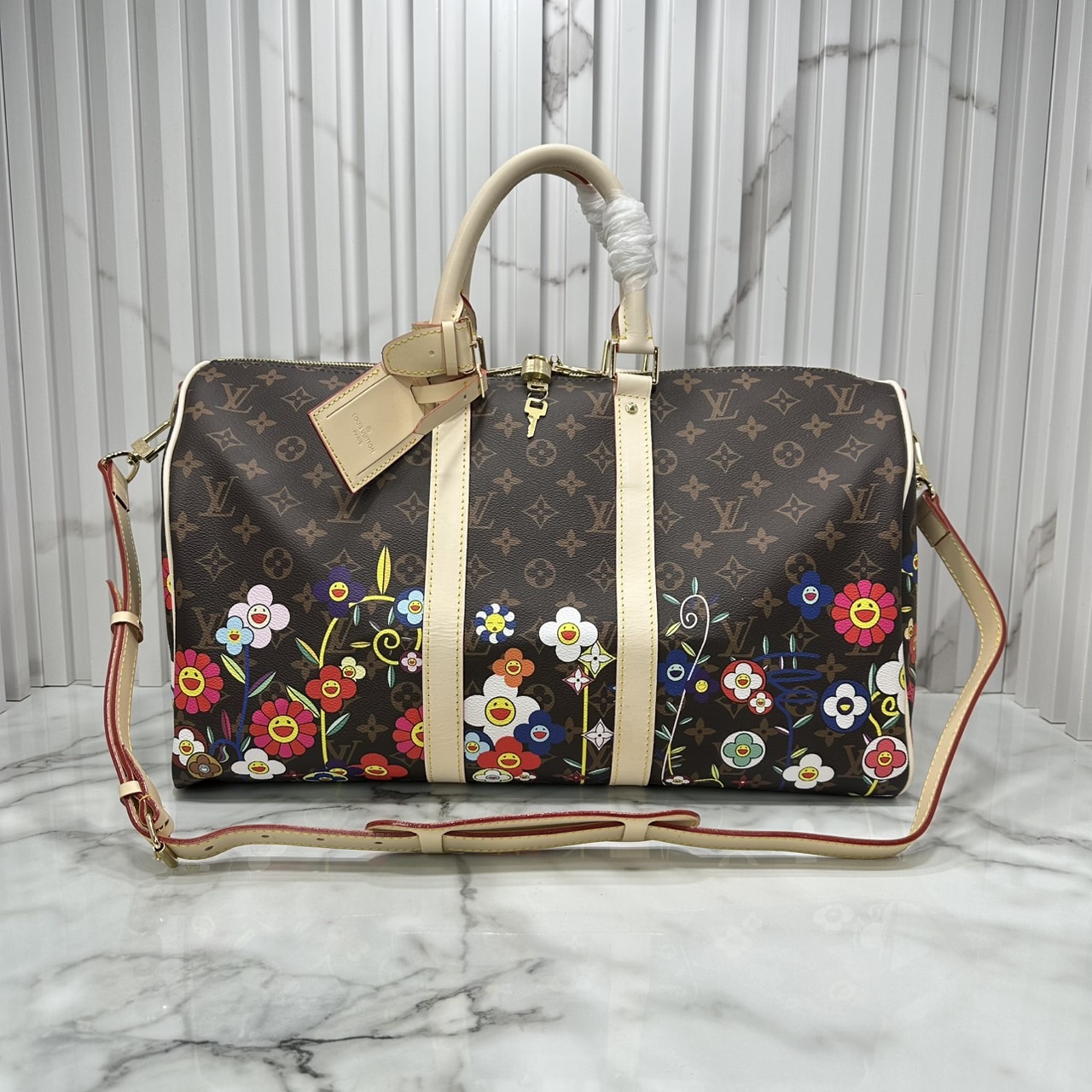 LV x TM Keepall Bandoulière 45 Bag Monogram Flower กระเป๋าเดินทางคอลเลกชันสุดพิเศษ สวยคลาสสิกมีชีวิตชีวา สีสันสดใสสไตล์ superflat สุดไอคอนิกของ Takashi Murakami ด้วยโมโนแกรมดอกไม้หลากสี ปรับดีไซน์ให้ดูสนุกสนาน