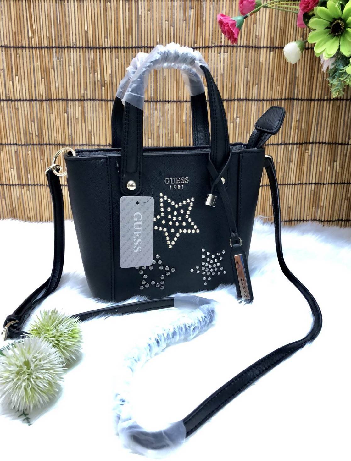 GUESS DELANEY MINI CROSSBODY BAG กระเป๋าถือหรือสะพายข้างได้ วัสดุหนังลาย saffiano ด้านหน้ามีโลโก้แบรนด์ พร้อมตกแต่งรูปดาว และ tag brand ห้อยที่หูกระเป๋า ตัวกระเป๋าเปิดแบบซิป ภายในโล่ง จุได้พอประมาณค่ะ มีช่องซิปอและช่องเล็ก มาพร้อม สายยาวปรับระดับได้ ราคาส