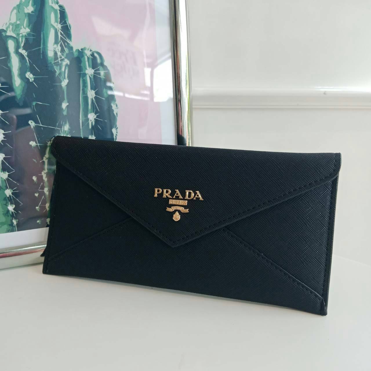 กระเป๋าสตางค์ยาว **ทรงหรู จากงานพรีเมี่ยมกิ้ฟ จากเคาเตอร์ต่างประเทศ จากแบรนด์ PRADA ลายหนัง saffiano ของแท้ 100% เปิดปิดฝาพับ มีช่องใหญ่1ช่อง ช่องใส่บัตร 3 ช่อง ใส่ได้ถึงแบงค์พัน หรือจะใส่มือถือได้ถึง Iphone+ และช่องซิปใส่ของจุกจิกด้านหลังน้ำหนักเบา จับถน