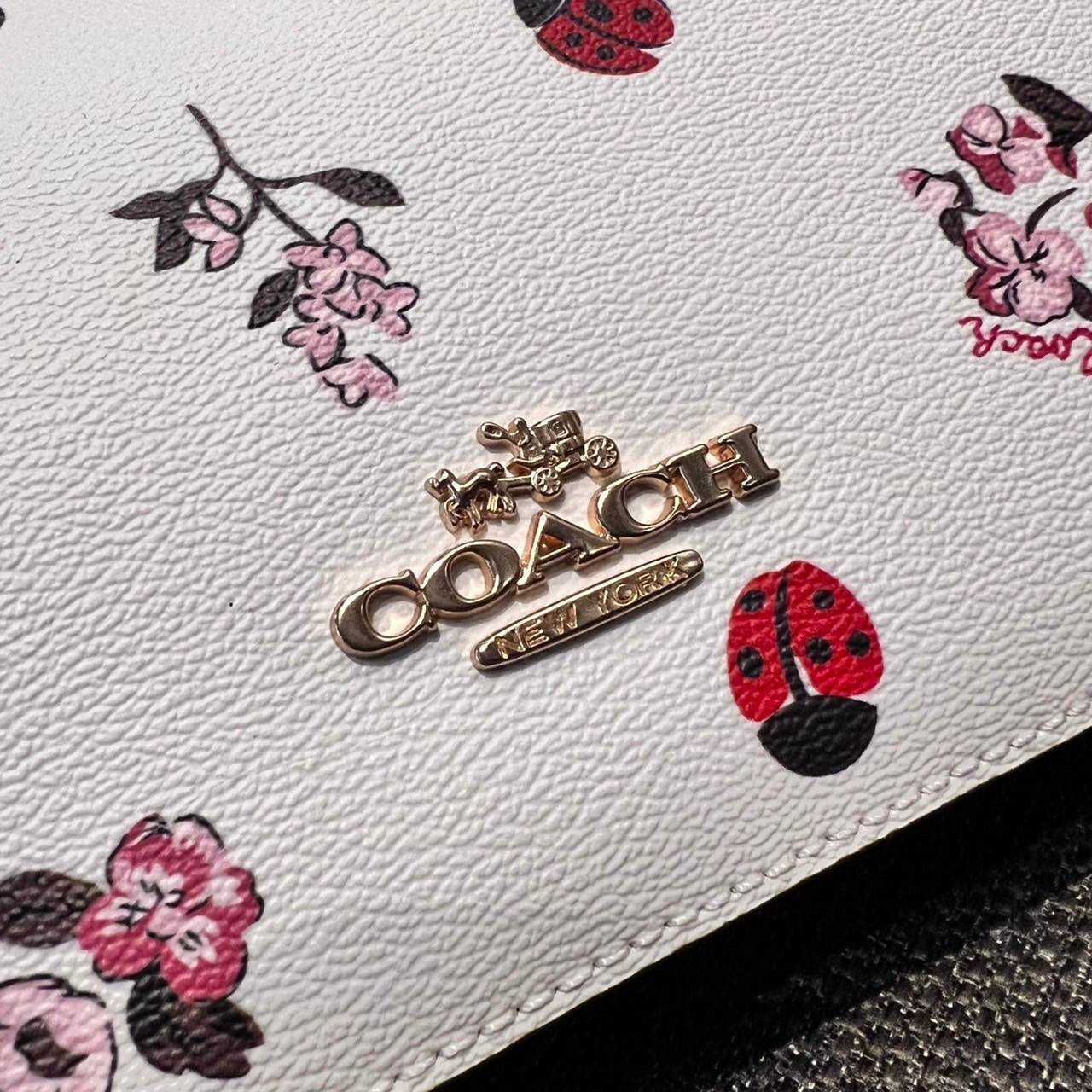 COACH C7973 JES BAGUETTE WITH LADYBUG FLORAL PRINT คอลเลคชั่นใหม่ล่าสุด พร้อมเสิร์ฟความสวยถึงบ้านเช่นเคย!! กระเป๋าสะพายทรงบาแกตต์ ดีไซน์ย้อนยุค ที่แอบแฝงความเรียบหรูดูแพงอยู่ในตัว โดดเด่นด้วยสายสะพายเส้นใหญ่ โทนสีคอนทราส ทำให้ไอเท็มนี้ดูมีลูกเล่นมากขึ้น ว