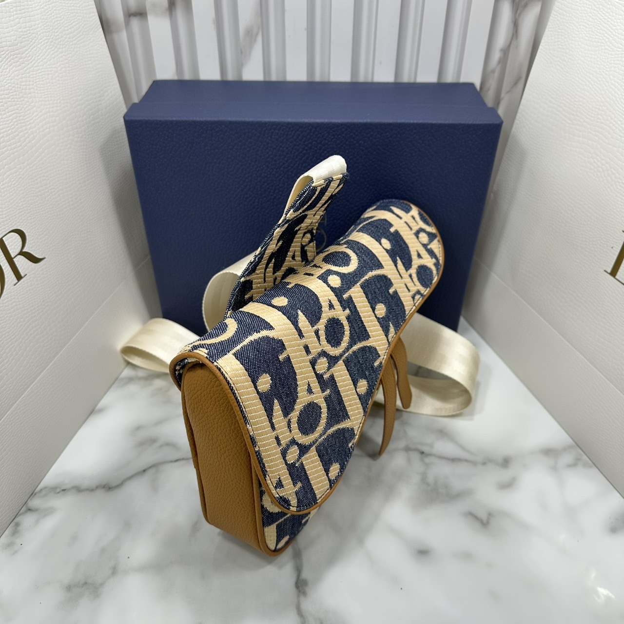 ORI หนังแท้ | DIOR Saddle Bag Blue and Beige Raffia-Effect Denim with Brown Grained Leather กระเป๋าสะพายคาดอก สัญลักษณ์สุดคลาสสิก ผ้าเดนิมลายแจ็คการ์ด Oblique พิมพ์ลายราฟเฟีย นำเสนอรูปแบบใหม่ให้กับไอคอนประจำแบรนด์