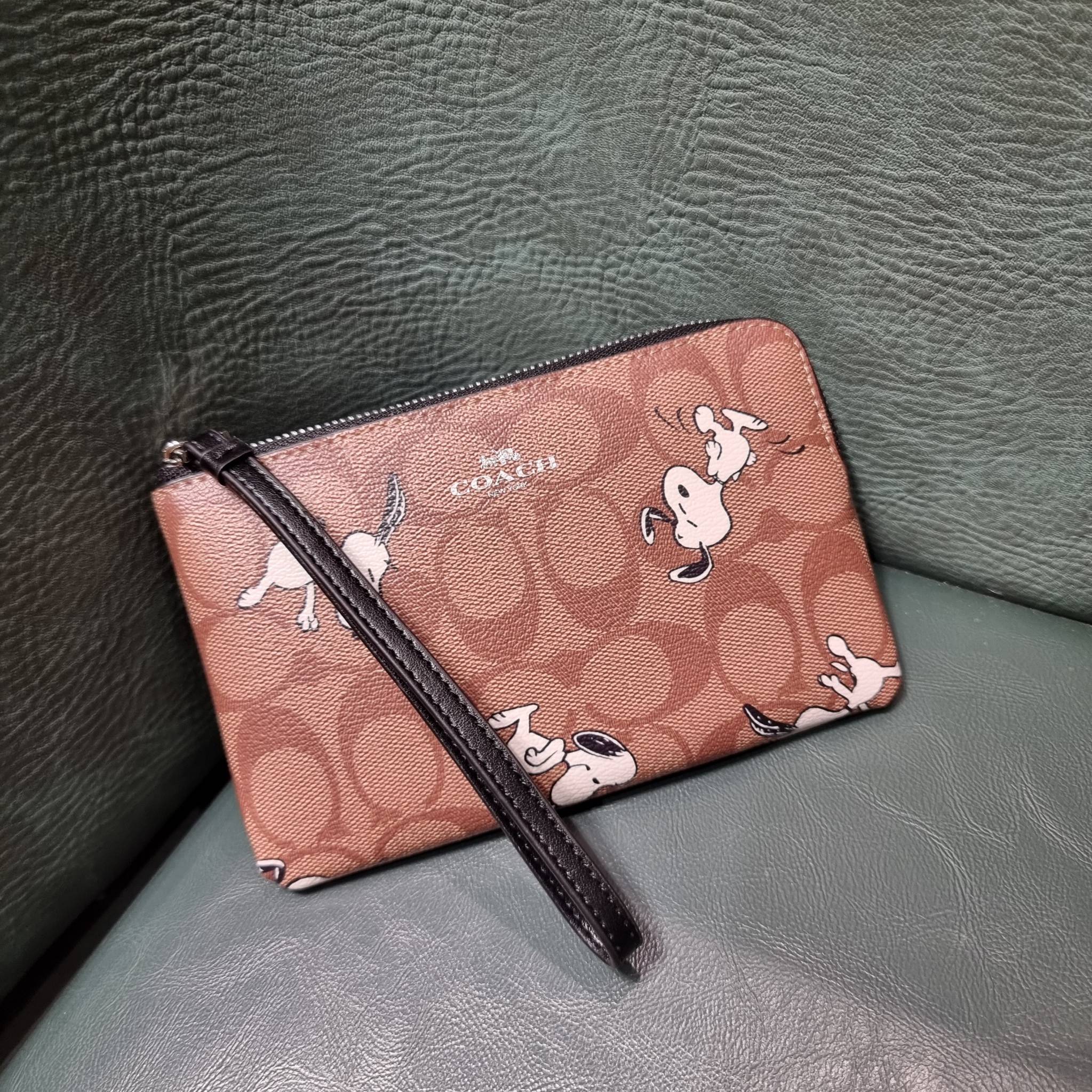 COACH C4589 COACH x PEANUTS CORNER ZIP WRISTLET IN SIGNATURE CANVAS WITH SNOOPY PRINT เหล่าผองเพื่อนและสนูปพีมาแล้วจ้า คอลเลคชั่นสุดน่ารักที่ฮอตไม่มีตก กระเป๋าคล้องมือ ขนาดเหมาะพกพากำลังเหมาะ วัสดุหนังแคนวาสเคลือบลาย ภายในเป็นช่องโล่ง ใส่ธนบัตร หรือใส่บัต