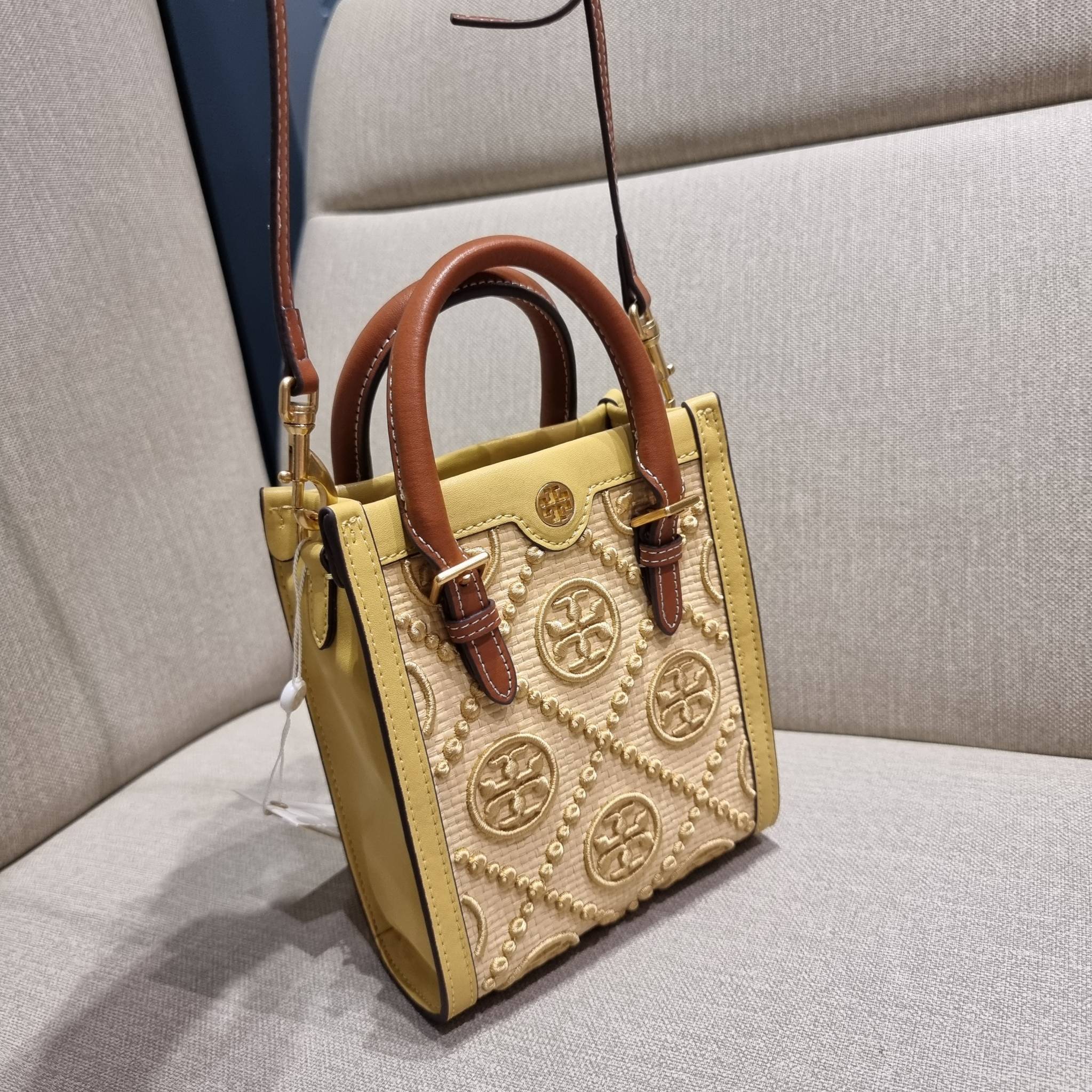 TORY BURCH T MONOGRAM STRAW MINI TOTE สวยสุด ดูแพงสุด!! ต้องยกให้เลย กับไอเท็มนี้ กระเป๋าสะพายทรงโท้ท ไซส์มินิ มีลูกเล่นที่ดีเทลเยอะมาก ด้วยงานฝีมือปักสานด้วยวัสดุจากกธรรมชาติ ถักทอเป็นลายเส้นขึ้นลายนูน ตัดขอบด้วยหนังแท้ และยังโดดเด่นด้วยหูจับในตัวโทนสีอุ