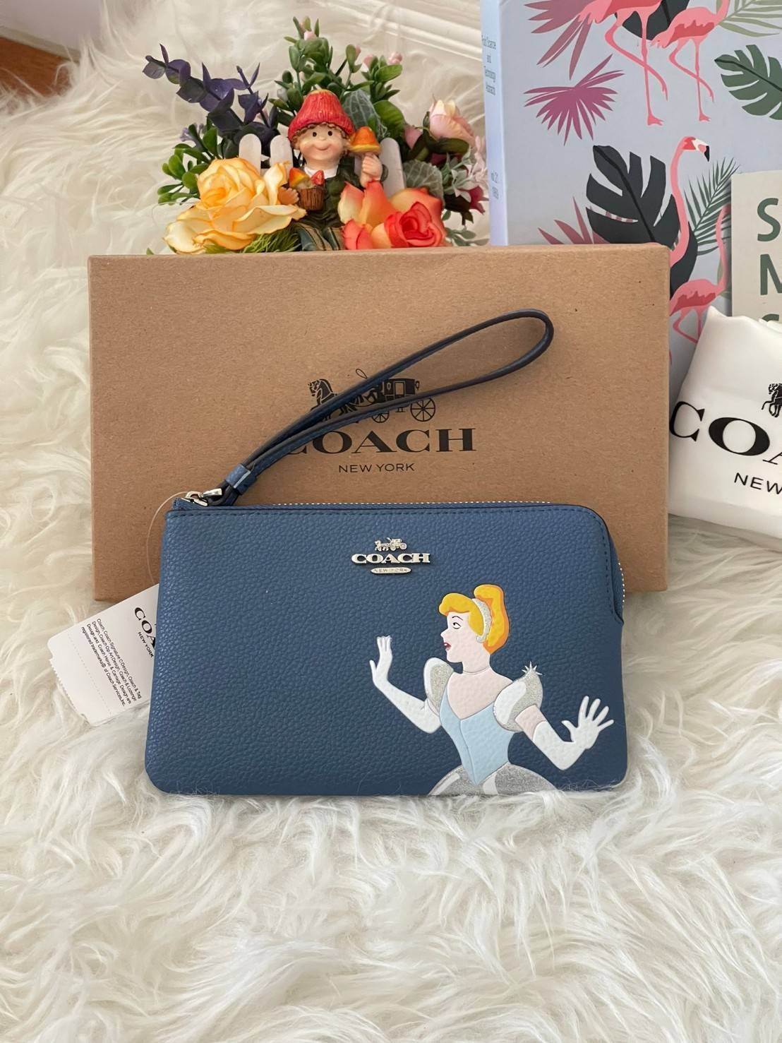 Coach & Disney Corner Zip Wristlet เปิดตัวคอลเลคชั่นเมื่อความดาร์กและโรแมนติกโคจรมาพบกัน เมื่อแบรนด์เครื่องหนังสัญชาติอเมริกัน Coach ร่วมมือกับ Disney สร้างสรรค์คอลเล็กชั่นพิเศษที่ได้รับแรงบันดาลใจมาจากเทพนิยายอเมริกันโกธิกของนิวยอร์ค ถ่ายทอดผ่านเหล่าตัวล