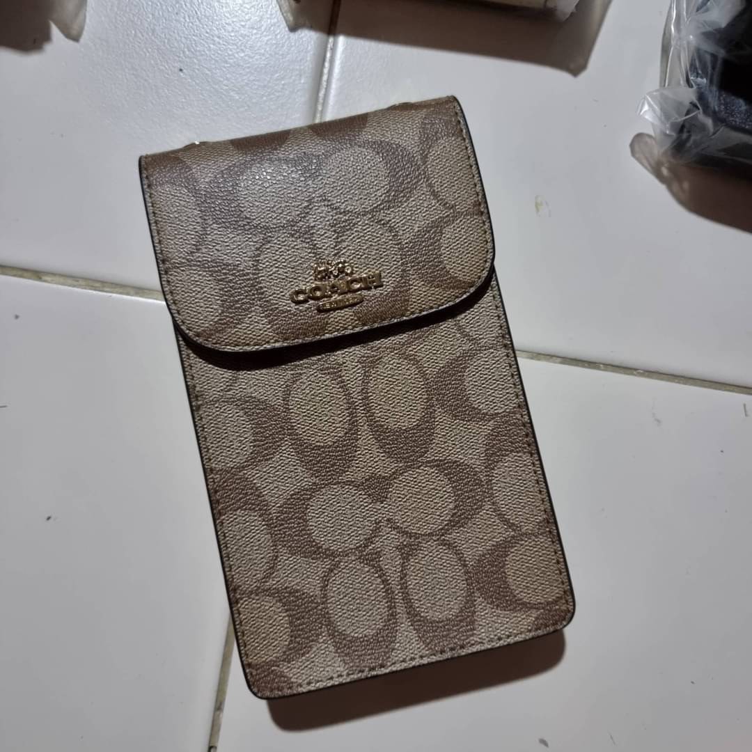 COACH NORTH/SOUTH PHONE CROSSBODY IN SIGNATURE CANVAS F55636 F39955 สุดคลาสสิคกับกระเป๋าสะพายเอนกประสงค์ Case phone ใส่โทรศัพท์มือถือได้ทุกรุ่น ดีไซน์ลายเอกลักษณ์ วัสดุหนังแคนวาสเคลือบลาย ฝาและภายในเป็นหนังสังเคราะห์เรียบ เปิด-ปิดด้วยกระดุม สายสะพายยาวประ