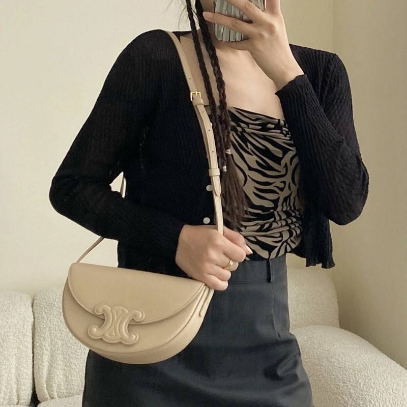 CELINE BESACE CUIR TRIOMPHE IN SMOOTH กระเป๋ารุ่นนี้นำเสนอในรูปทรงฮาล์ฟมูนที่ตอนนี้กำลังงมาแรง เปิดด้วยกระดุมแป๊กเพื่อเผยให้เห็นช่องภายในที่กว้างขวางและกระเป๋าด้านในแบบแบน คุณสมบัติที่โดดเด่นอีกอย่างของกระเป๋าอยู่ที่โลโก้ขนาดใหญ่ รูปทรงสะดุดตา สามารถสะพาย