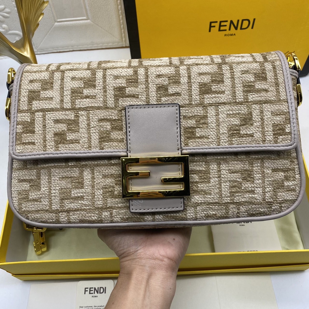 Fendi Baguette FF Tapestry Fabric Bag เกรดออริจินอล กระเป๋าทรง Baguette ขนาดกลาง วัสดุผ้าเซนิล พร้อมลวดลาย FF สีเทาเข้ม ปิดท้ายด้วยรายละเอียดหนังแบบทูโทนและประดับด้วยตัวล็อค FF โดดเด่นด้วยฝาปิดด้านหน้าตัวล็อคแม่เหล็กช่องด้านในบุด้วยผ้าหนังกลับพร้อมกระเป๋า