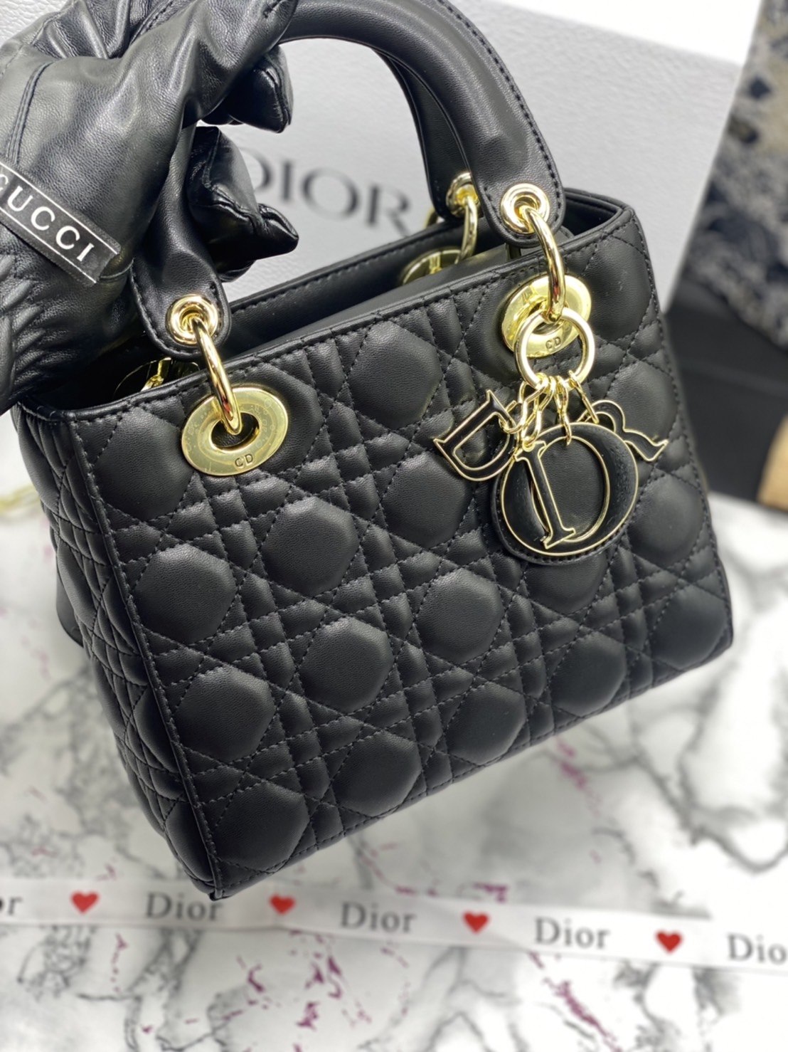 หนังแท้ DIOR LADY BAG 20cm ความสง่างามอีกหนึ่งรุ่นของ Dior รูปทรงสีเหลียม ขนาดกระทัดรัด ตั้งอยู่ทรง ฐานกระเป๋าแข็งแรง มีหมุดรองฐาน ดีไซน์ที่มีเอกลักษณ์เฉพาะตัว ด้านหน้าตกแต่งด้วยตัวอักษร D.I.R ห้อยเป็นพวงกุญแจ จะถือด้วยมือหรือสะพายไหล่ก็ดูดีมากๆ ค่ะ