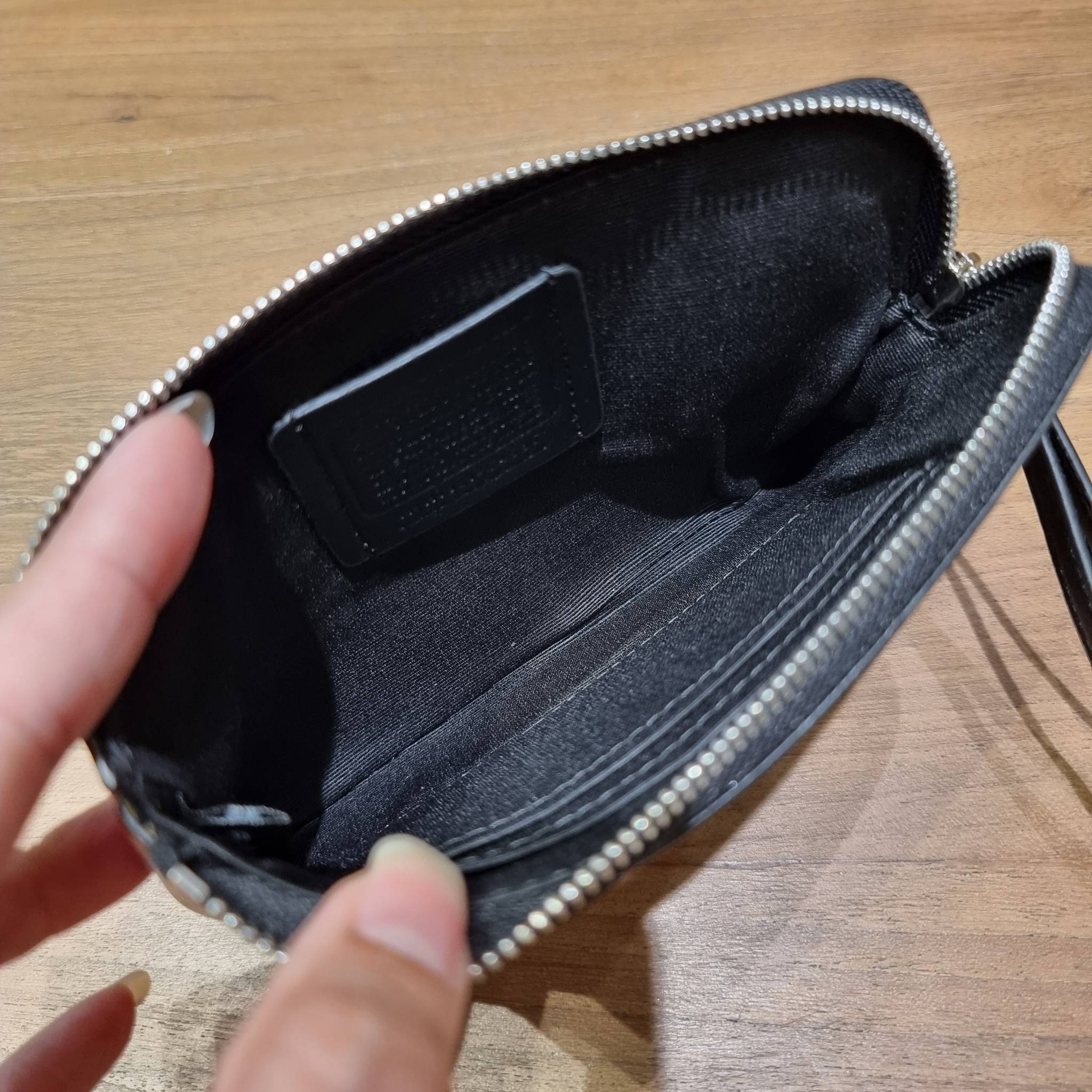 COACH C4589 COACH x PEANUTS CORNER ZIP WRISTLET IN SIGNATURE CANVAS WITH SNOOPY PRINT เหล่าผองเพื่อนและสนูปพีมาแล้วจ้า คอลเลคชั่นสุดน่ารักที่ฮอตไม่มีตก กระเป๋าคล้องมือ ขนาดเหมาะพกพากำลังเหมาะ วัสดุหนังแคนวาสเคลือบลาย ภายในเป็นช่องโล่ง ใส่ธนบัตร หรือใส่บัต