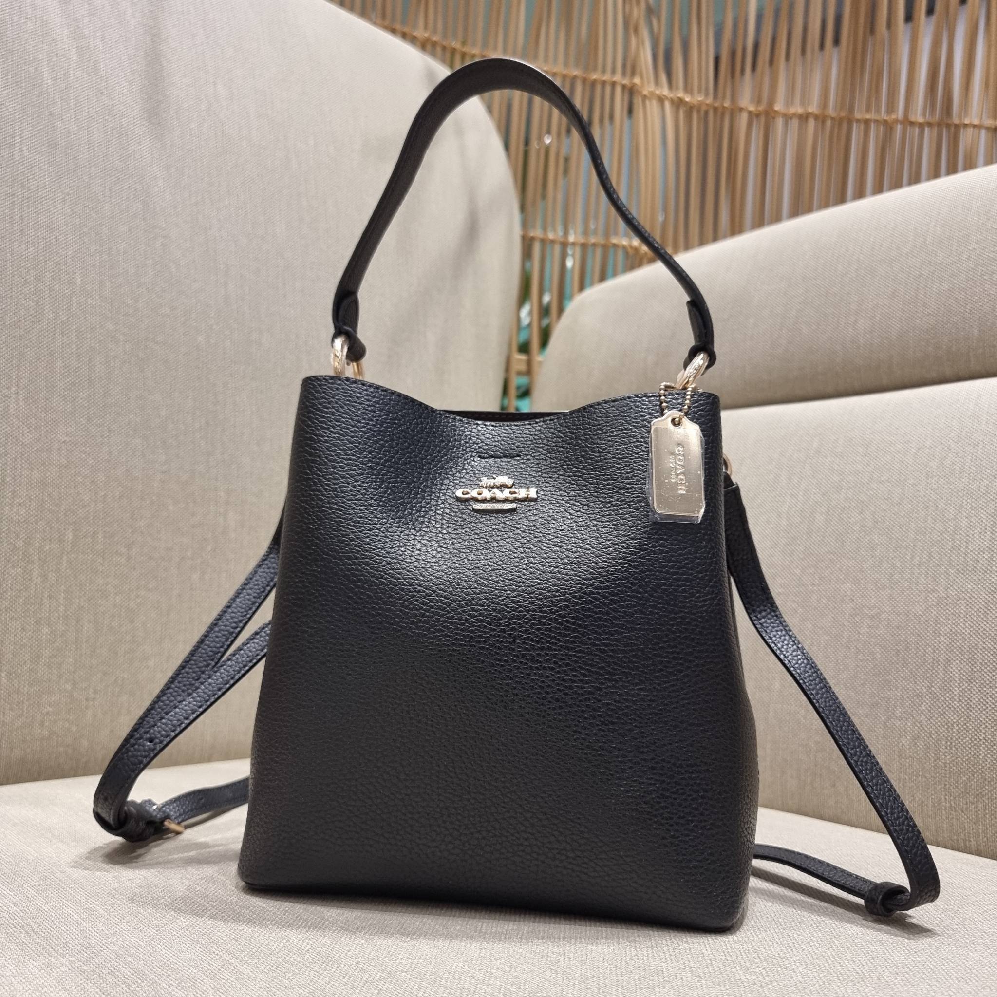 COACH 1011 SMALL TOWN BUCKET BAG รุ่นยอดนิยมใบเล็ก กระเป๋าทรงบัคเก็ต สีคลาสสิคเรียบหรู ตัดกับโลโก้สีทองดูโดดเด่น วัสดุหนัง pepble สวยคมทุกมุมจริงๆ!! เปิด-ปิดด้วยกระดุมแม่เหล็กทั้ง 2 ฝั่ง ภายในเป็นช่องโล่ง มาพร้อมสายสะพายปรับได้ตามตัว ขนาดใบนี้กำลังสวย สะพ