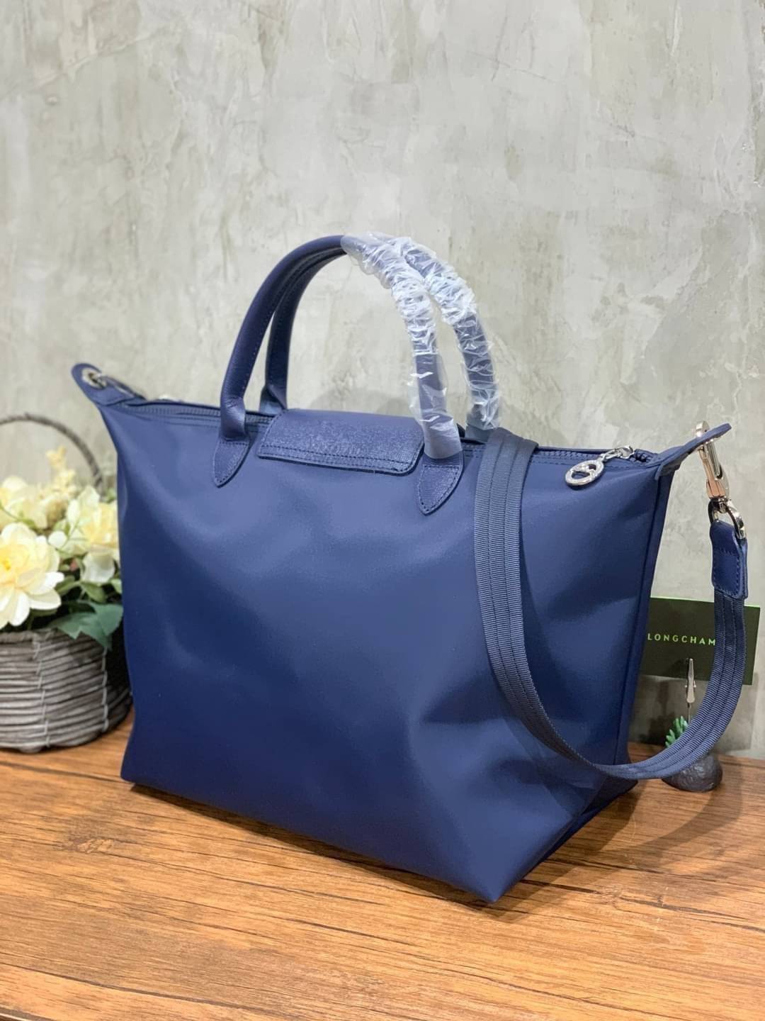 Longchamp Le Pliage Neo Size M มาพบกับกระเป๋ารุ่นยอดนิยม ที่สาวๆ ต้องมีไว้เก็บไว้สักใบ กระเป๋าโท้ทใบนี้ มาพร้อมกับสีที่มีสไตล์เรียบง่าย มีสายสะพายยาวช่วยให้คุณสามารถสะพายไหล่ได้อย่างสบาย ในขณะที่ที่ปิดแบบซิปช่วยให้คุณมั่นใจได้ว่าของด้านในมีความปลอดภัย Le 