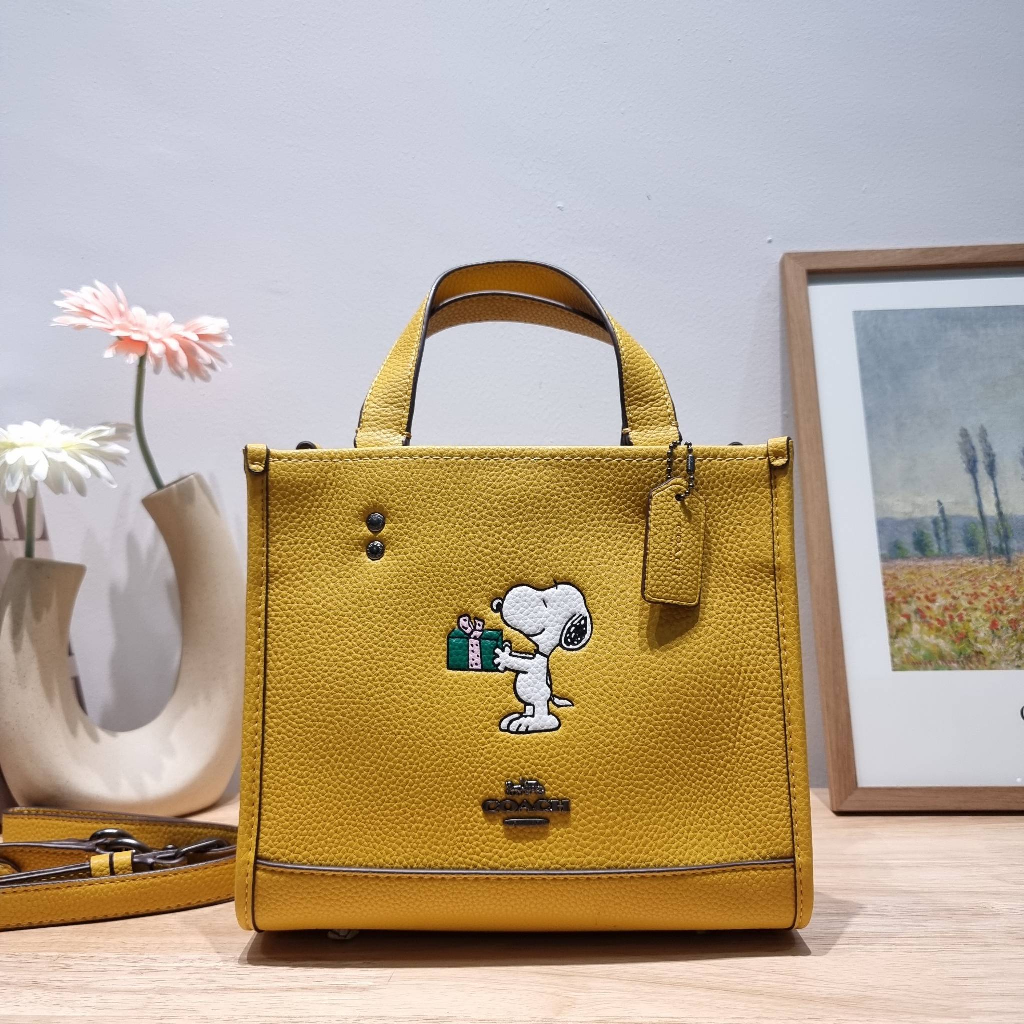 coach x peanuts dempsey tote 22 with snoopy present motif CE918 คอลเลคชั่นใหม่ น้องน่ารักเกินต้านไปมาก!! กับกระเป๋าทรงโท้ท ไซส์กำลังสวย ดีไซน์ ลายการ์ตูนยอดฮิต ที่ใครๆก็ต้องรู้จัก พิมพ์คมชัดลงบนหนัง pepble ผิวสัมน่าใช้ ปากกระเป๋ามีกระดุมแม่เหล็กปิดกันของห
