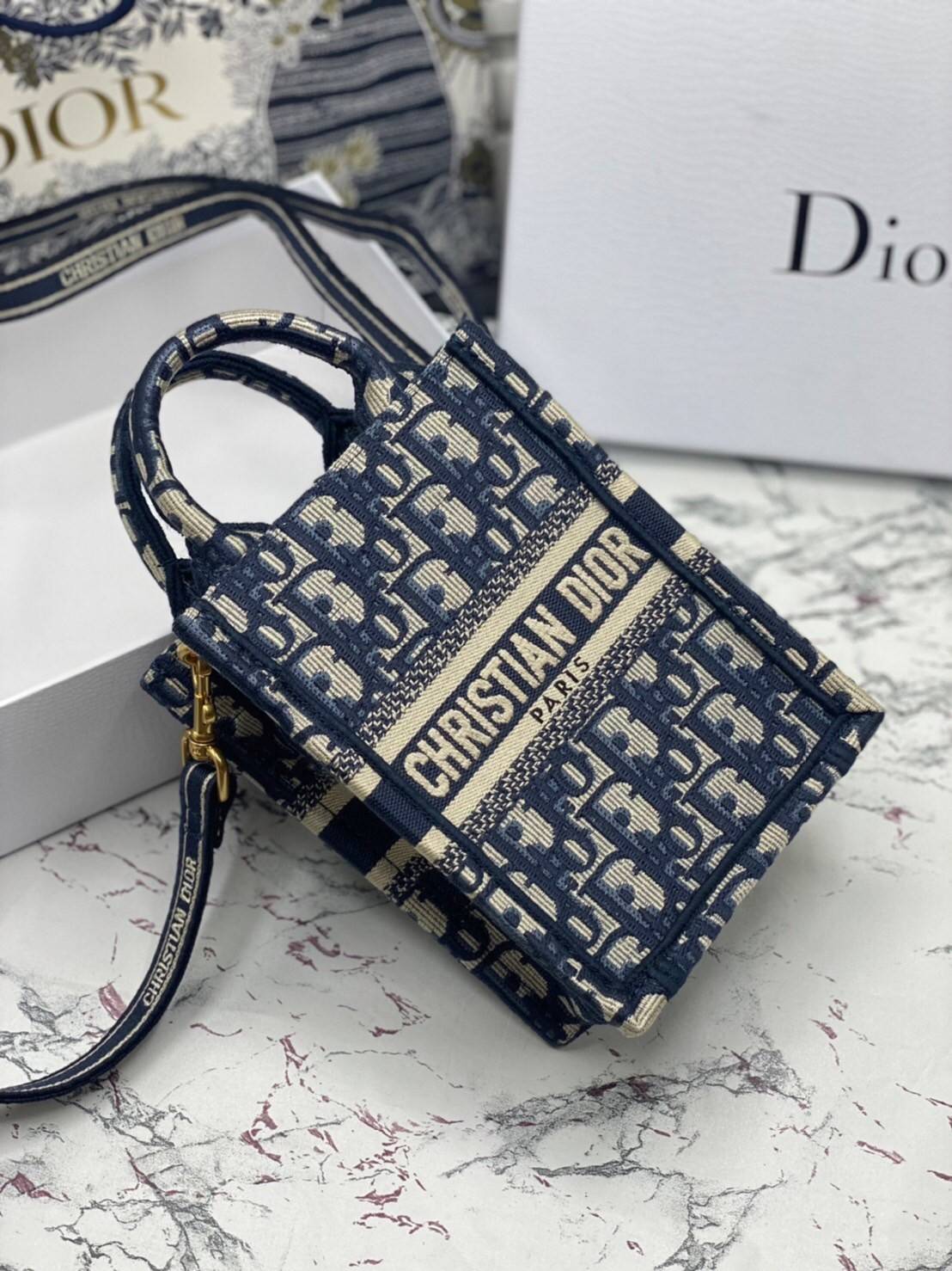 ORI 】Mini Dior Book Tote Phone Bag Blue Dior Oblique Embroidery พร้อมส่งที่ไทย ภาพสินค้าถ่ายจากงานขายจริง ใช้งานต่างประเทศได้ กระเป๋าใบมินิจะใส่โทรศัพท์ได้เช่นเดียวกับของใช้จำเป็นเล็กๆ น้อยๆ ในแต่ละวัน มาพร้อมสายสะพายไหล่แบบปักที่ปรับได้และถอดออกได้ อุปกร
