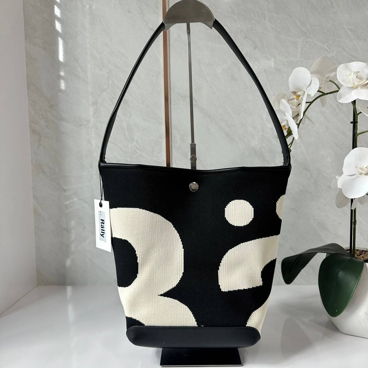 Rally movement the bag Knit Black เป็นไอเท็มที่ฮอตสุดๆแห่งปีจริงๆ กับกระเป๋าทรงบัคเก็ต น้ำหนักเบาๆ ฮอทติดลมบน จุของได้แบบหนำใจ ทอลายโลโก้ด้วยเทคนิค Sturdy Stretch Knit