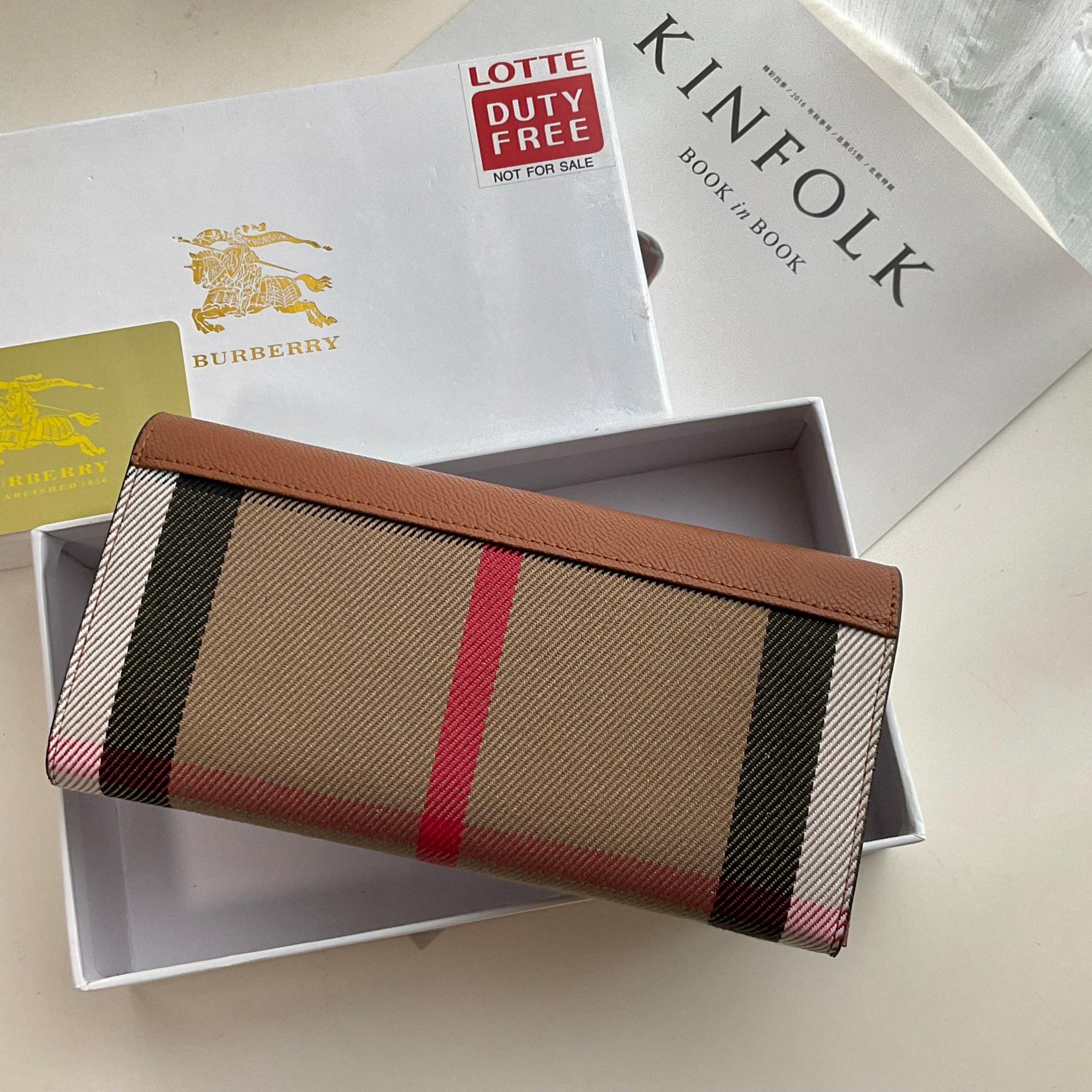 กระเป๋าสตางค์รับทรัพย์ ทรงหรู จากงาพรีเมี่ยมกิ๊ฟ Limited Edition จาก BURBERRY กระเป๋าสตางค์ใบยาวแบบพับกระดุม ทูโทนด้วยหนังแท้คาดผ้าลาย vintage ด้านในมีช่องใส่ธนบัตรยาวทั้งสองฝั่ง ช่องใส่บัตรได้อย่างน้อย 12 ช่อง และช่องเปิดด้วยซิปปั้มแบรนด์อะไหล่ทองสุดหรู 