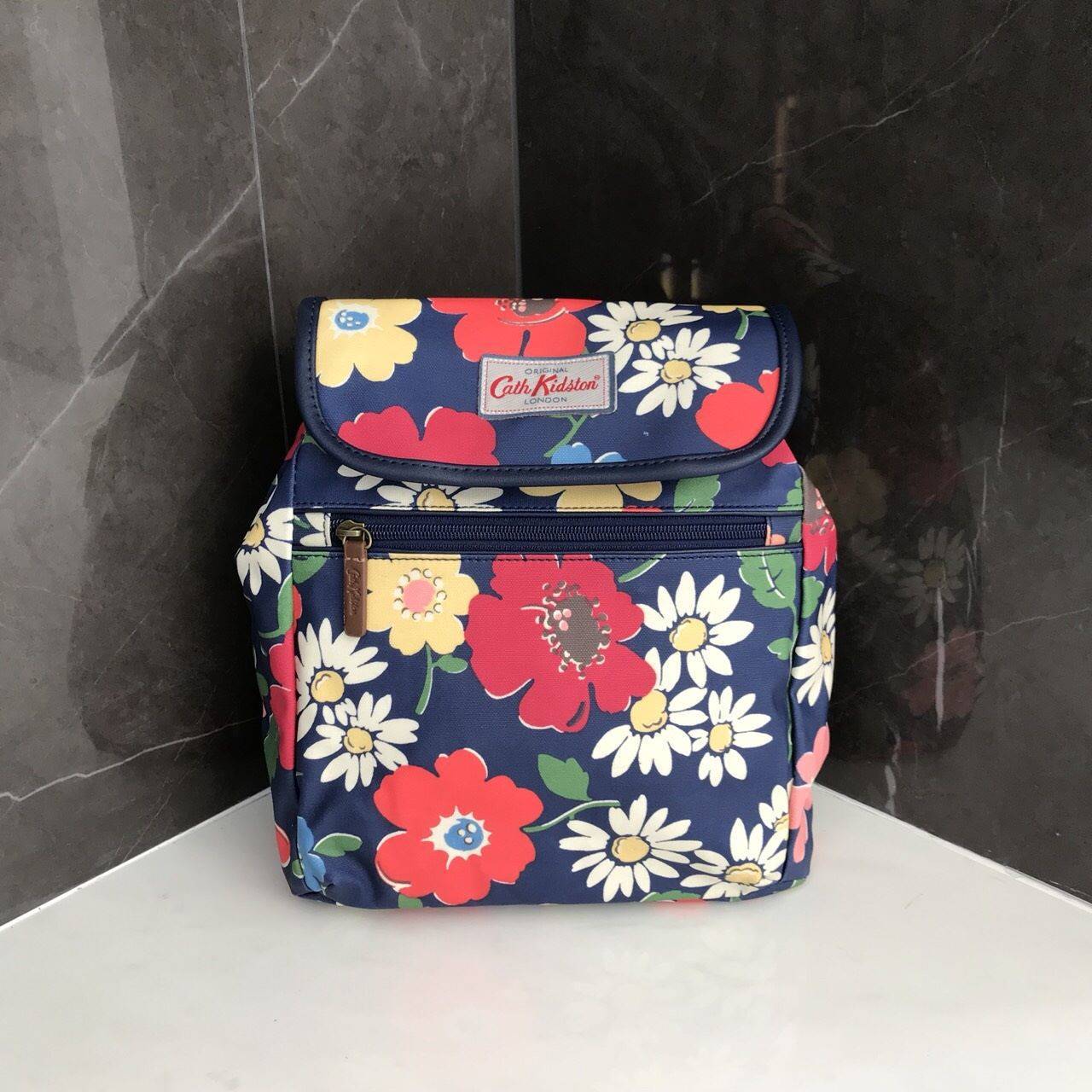 Cath Kidston Backpack Bag กระเป๋าถือหรือเป้สะพายหลัง วัสดุCanvas+Polyester อย่างดี เนื้อหนา น้ำหนักเบา ประดับโลโก้ด้านหน้า เปิดปิด ด้วยกระดุมเเม่เหล็กทั้งด้านนอก/ใน มีช่องซิปด้านหน้าใส่ กระเป๋าสตางค์ หรือมือถือได้ หัวซิปหนังปั๊มโลโก้ ภายในมี ช่องเล็ก 1 ช่