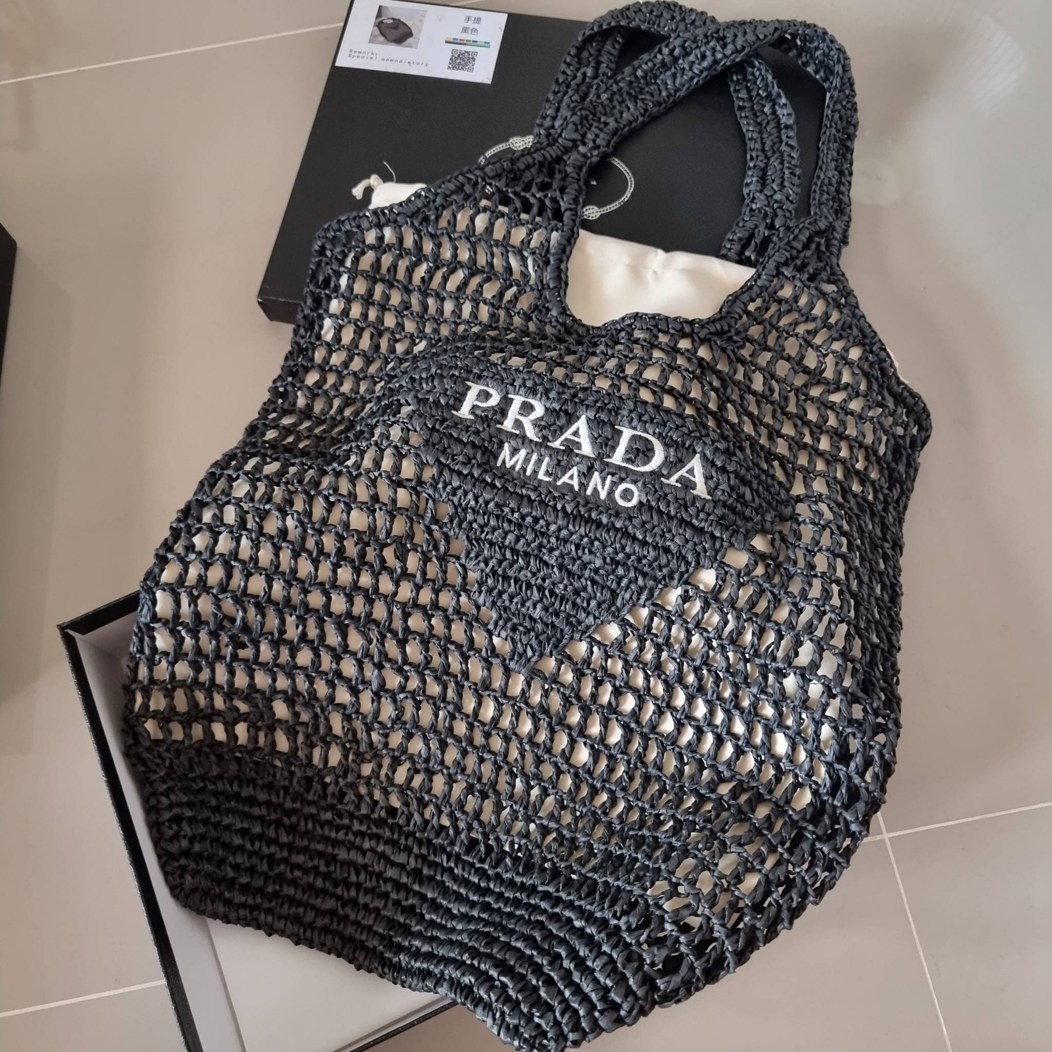 PRADA RAFFIA TOTE BAG สวยไม่ซ้ำใคร สไตล์บีช เหมาะมากกับการสะพายไปเที่ยวทะเล หรือจะใช้ในวันสบายๆก็ตอบโจทย์ กับกระเป๋าสะพายสานใบใหญ่ ตัวกระเป๋าเป็นวัสดุสังเคราห์จากธรรมชาติ