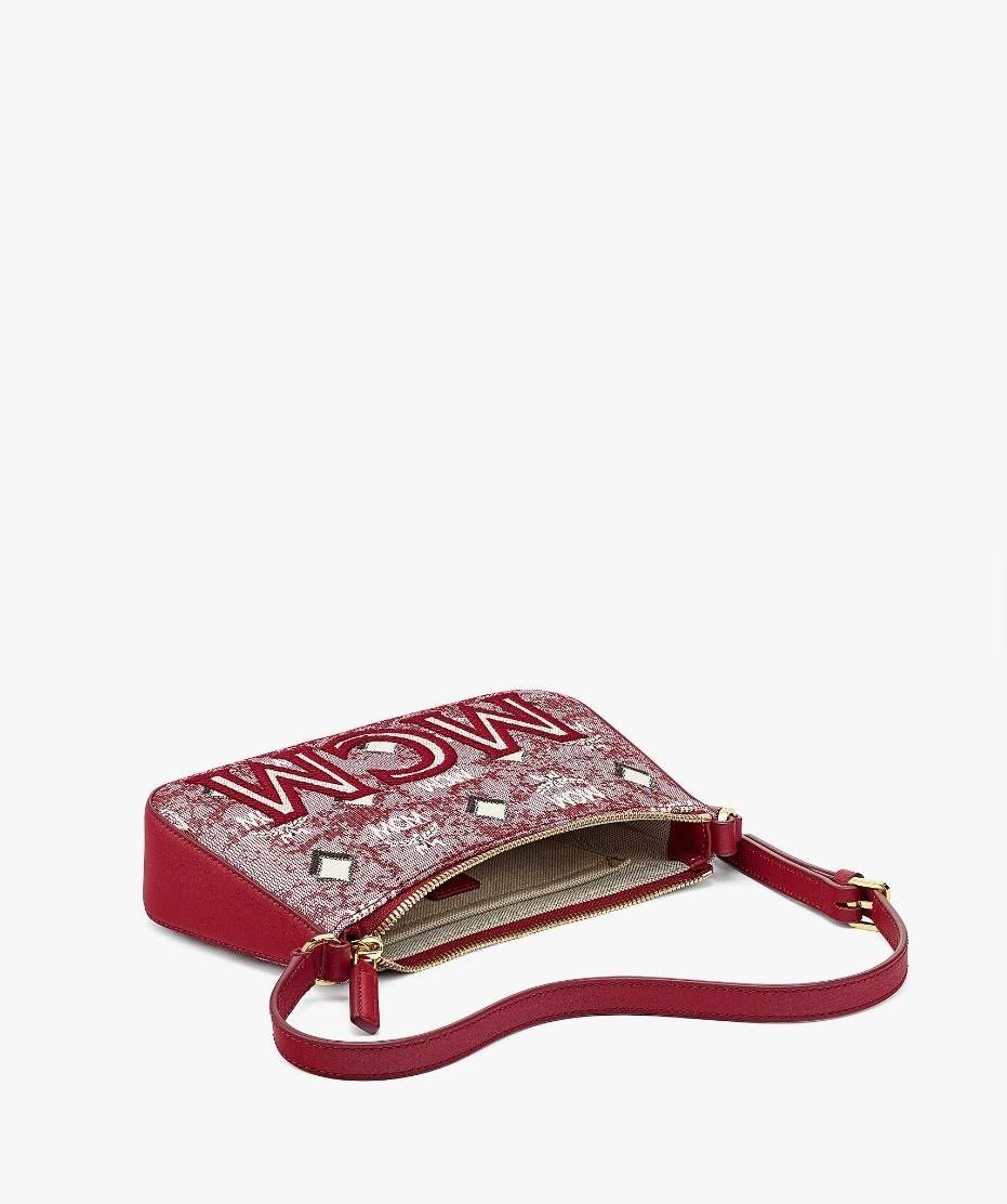 M.C.M MINI SHOULDER BAG IN VINTAGE JACQUARD MONOGRAM คอลเลคชั่นใหม่ล่าสุด โดดเด่นด้วยลายโมโนแกรม ถักทอบนผ้า woven jacquard กระเป๋าสะพายทรงพอชที่ไม่ธรรมดา มาพร้อมสายสะพายในตัว สามารถปรับใช้ได้ 2 แบบ สายยาวสะพายข้าง หรือจะนำสายเส้นกลางออกและปรับใช้สะพายไหล่