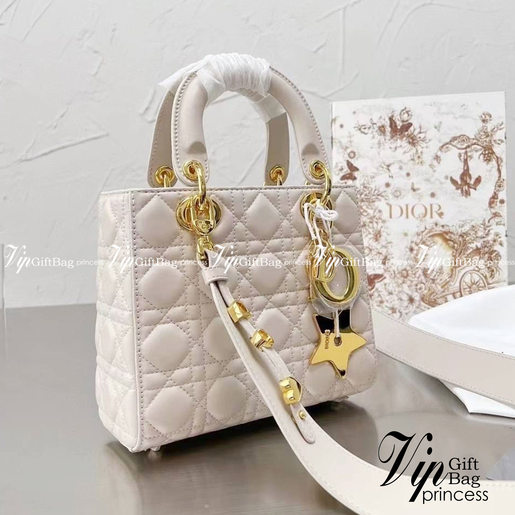 DIOR Lady / Small Lady Dior Bag Cannage Lambskin กระเป๋าสุดไอคอนิก รูปทรงสีเหลียม ขนาดกระทัดรัด ตั้งอยู่ทรง ฐานกระเป๋าแข็งแรง มีหมุดรองฐาน ดีไซน์เอกลักษณ์เฉพาะตัว ด้านหน้าตกแต่งด้วยตัวอักษร D.I.R ห้อยเป็นพวงกุญแจ จะถือหรือสะพายไหล่ก็ดูดีมากๆ ค่ะ