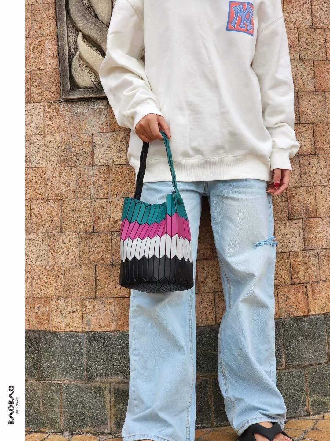 Large : Baobao Issey Miyake Large Bucket กระเป๋าบัคเก็ตขนาดใหญ่สามารถใช้ใส่ร่มพับได้หรือขวดน้ำขนาดเล็กได้ ซีรีย์ใหม่นี้มีจุดเด่นที่แผ่นรูปทรงสี่เหลี่ยมด้านขนานในแนวตั้ง เกิดเป็นรูปทรงสามมิติซึ่งแตกต่างไปจากรูปทรงที่เกิดขึ้นจากแผ่นสามเหลี่ยม หูหิ้วสามารถขย